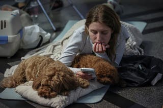 A woman takes shelter with her dogs inside an overcrowded metro station during a Russian missile and drone strike