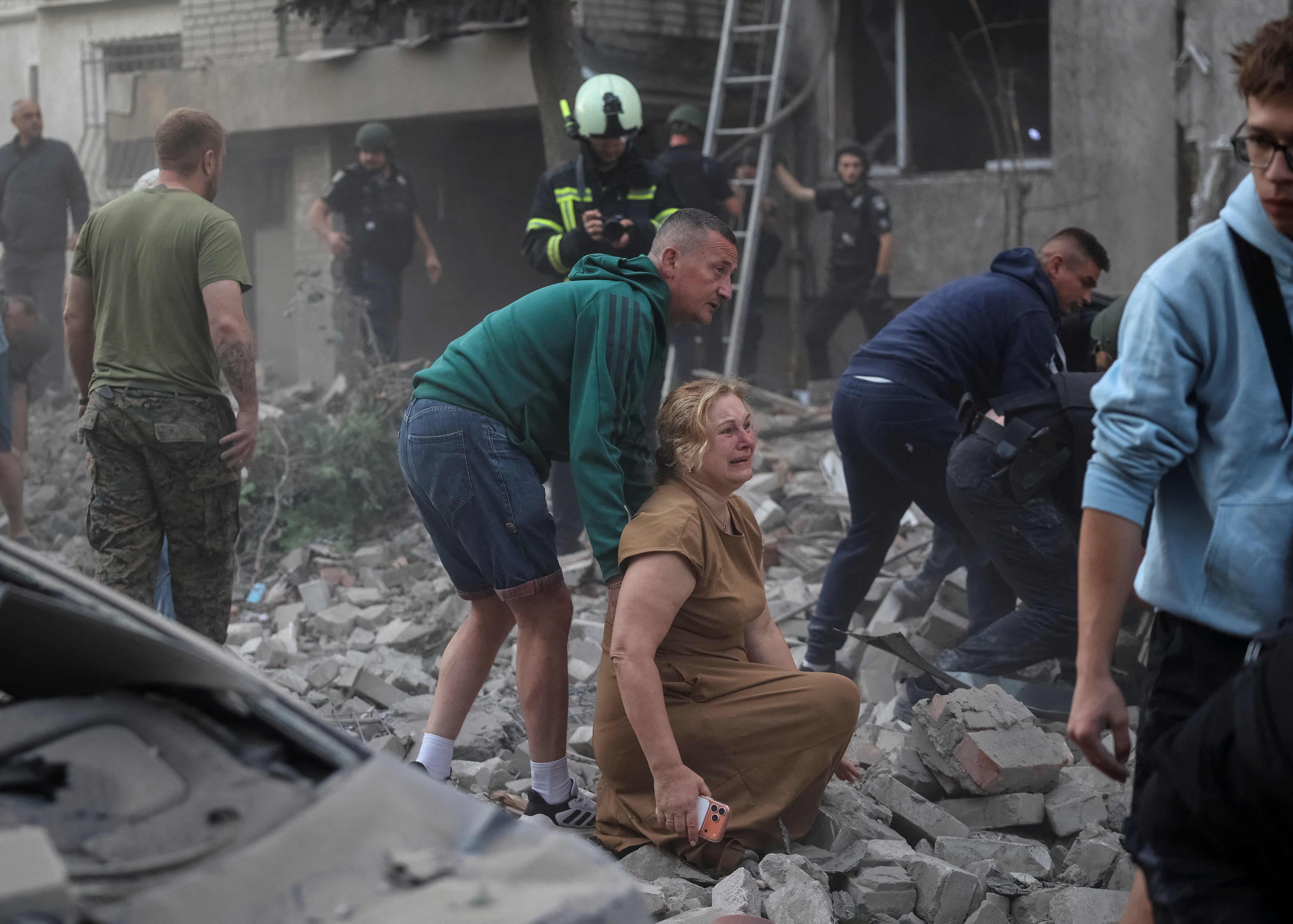 A woman reacts near an apartment building hit by a Russian missile strike, amid Russia's attack on Ukraine