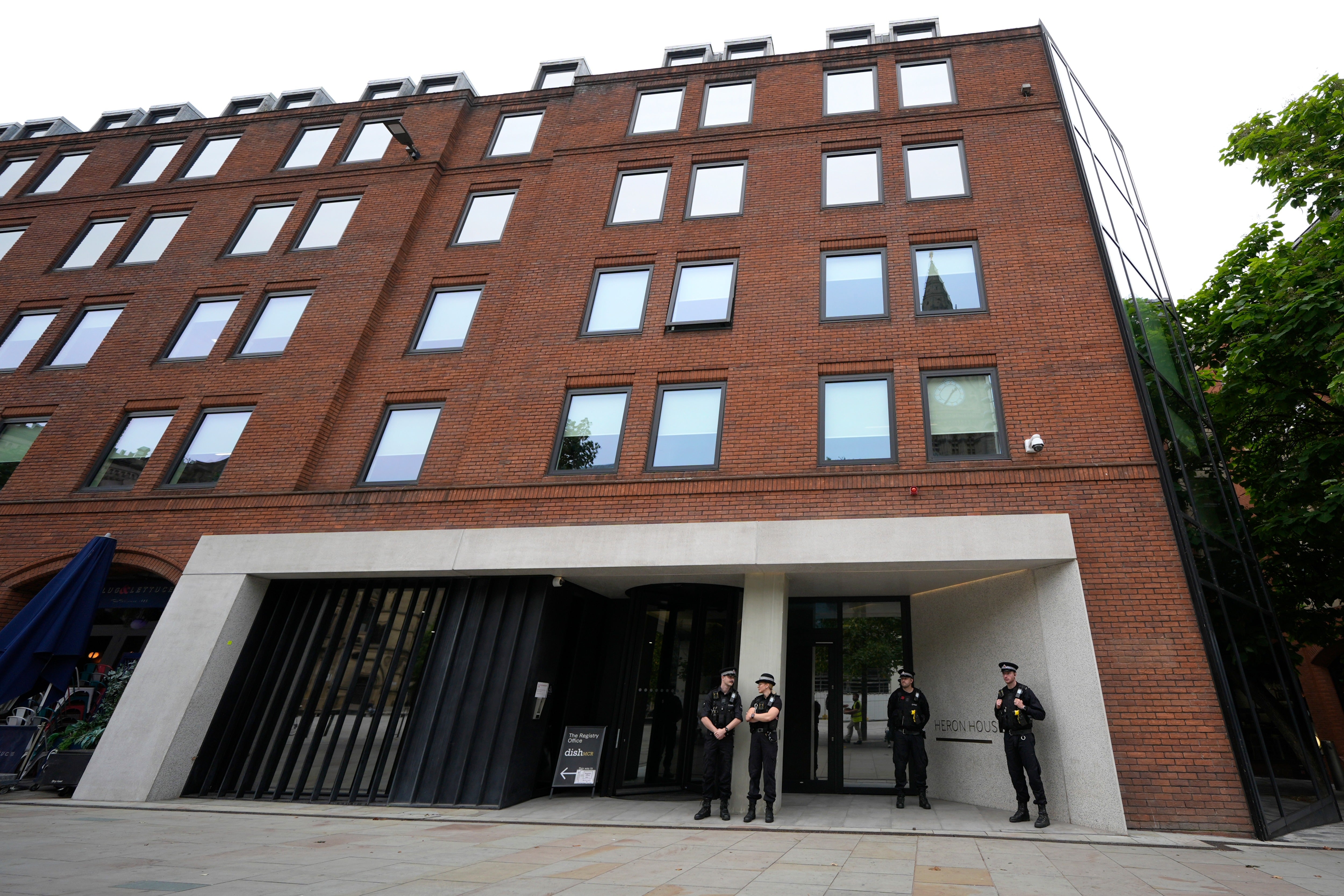 Police officers outside No 10 North, located in Heron House, central Manchester
