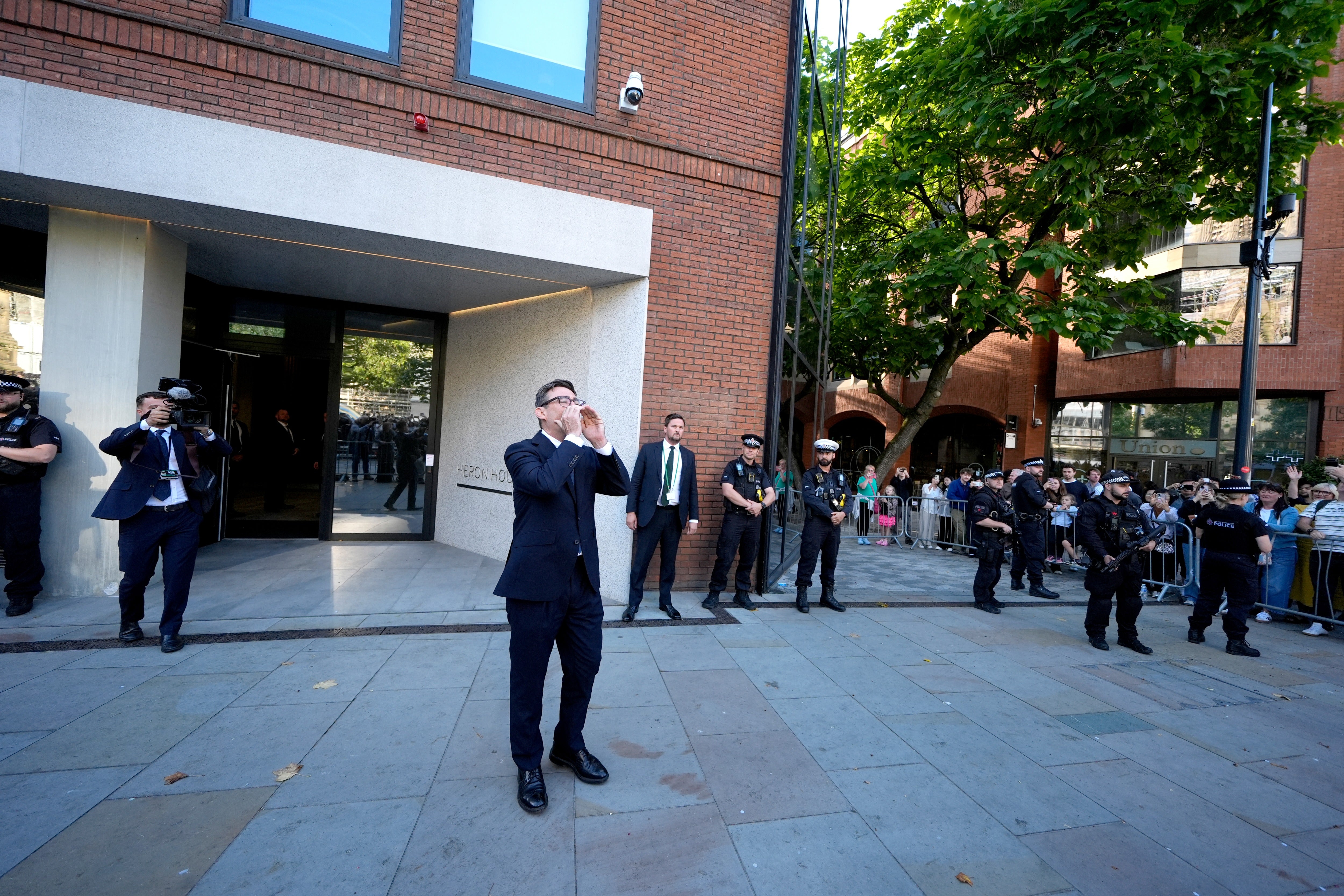 Andy Burnham comes out of No 10 North located in Heron House, central Manchester, to greet a crowd after holding a meeting