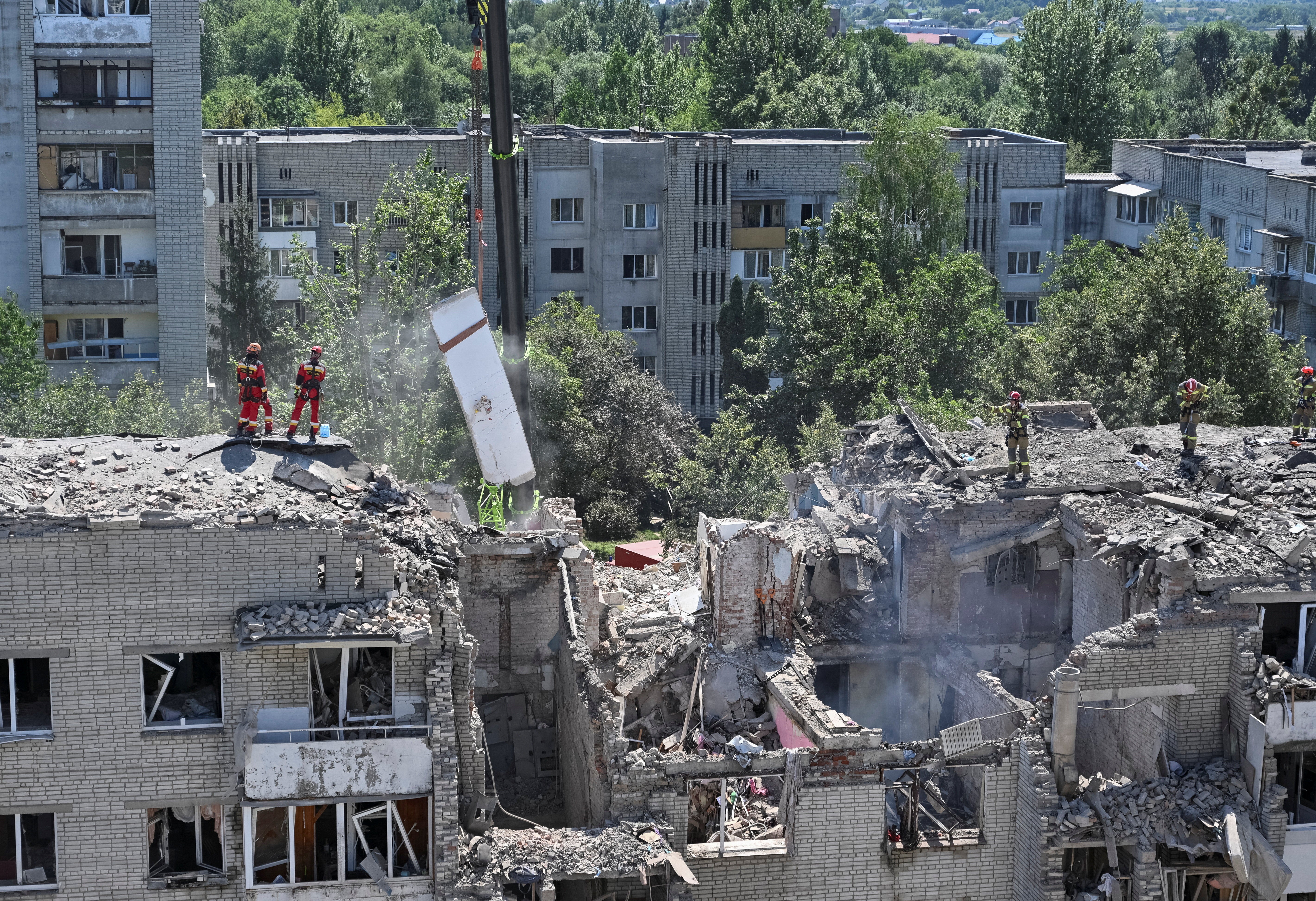 Rescuers in Lviv work at the site of an apartment building hit by a Russian missile strike on Thursday (Reuters)