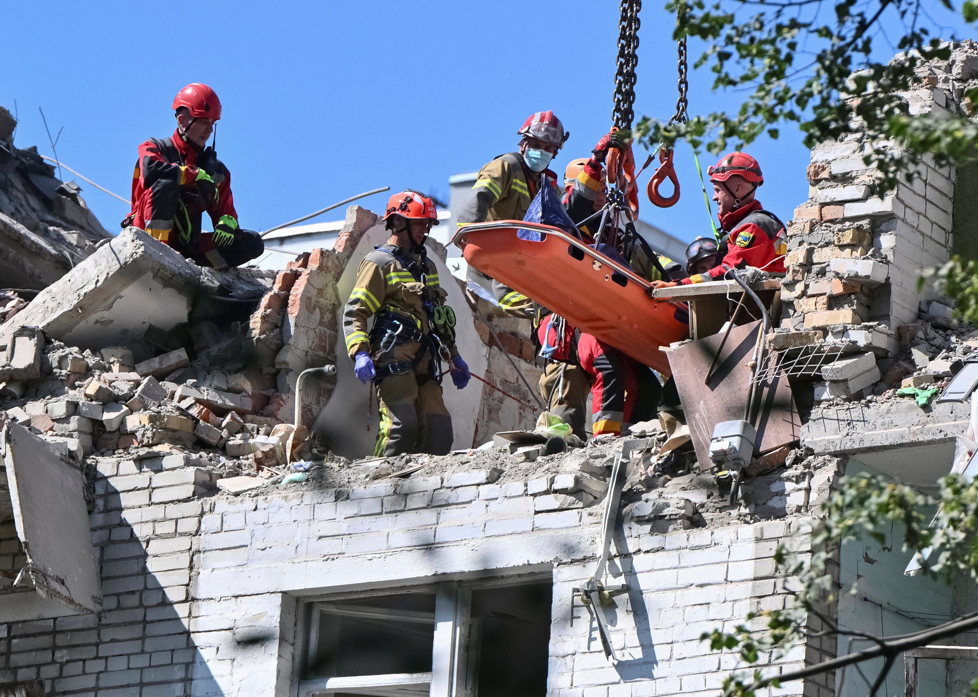 Rescuers use a crane to carry the body of someone killed during Russian strikes on Lviv (Reuters)