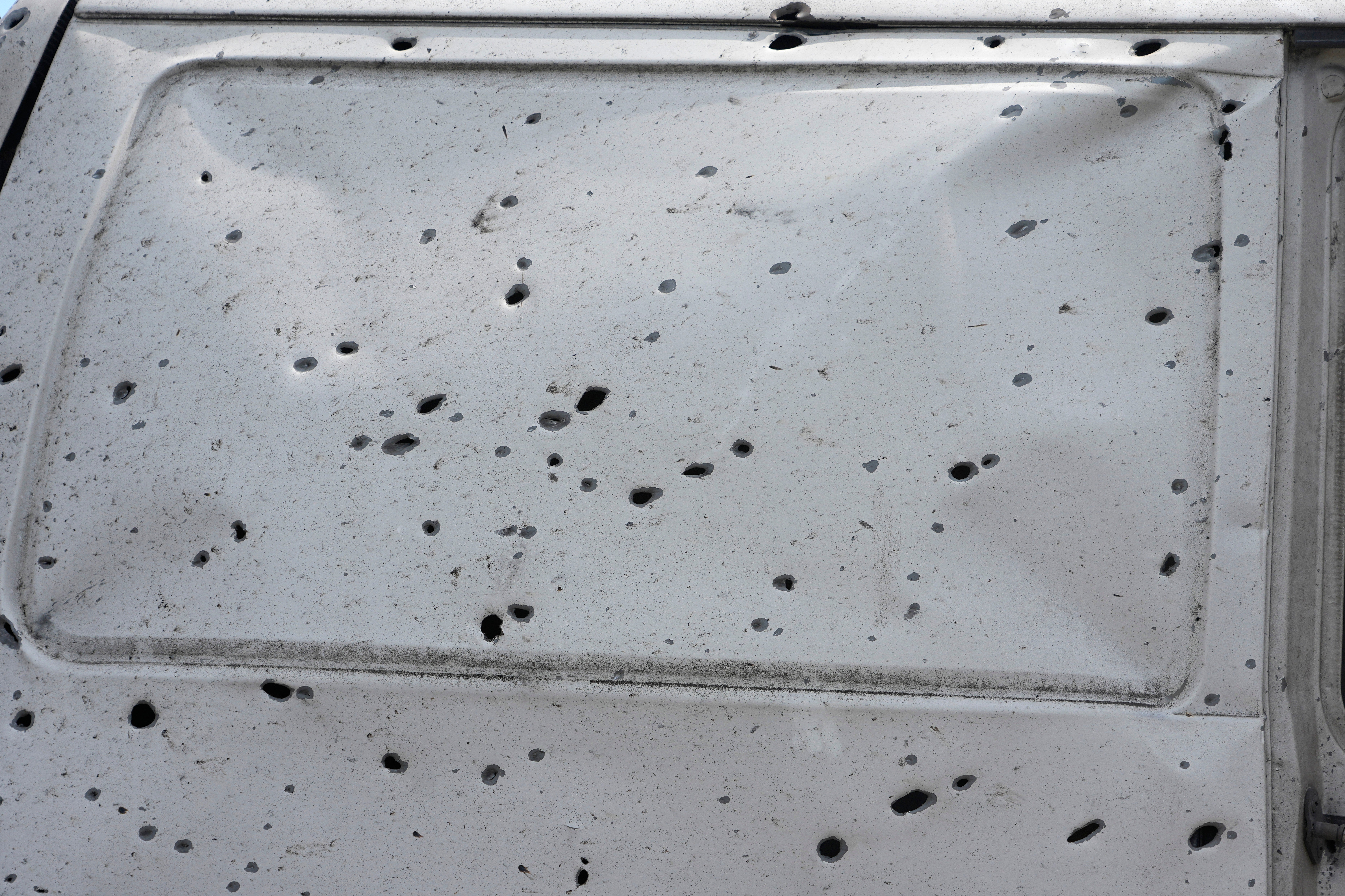 A shrapnel-damaged car door is seen among the ruins of city market place following Russian missile attack in Kyiv (AP)