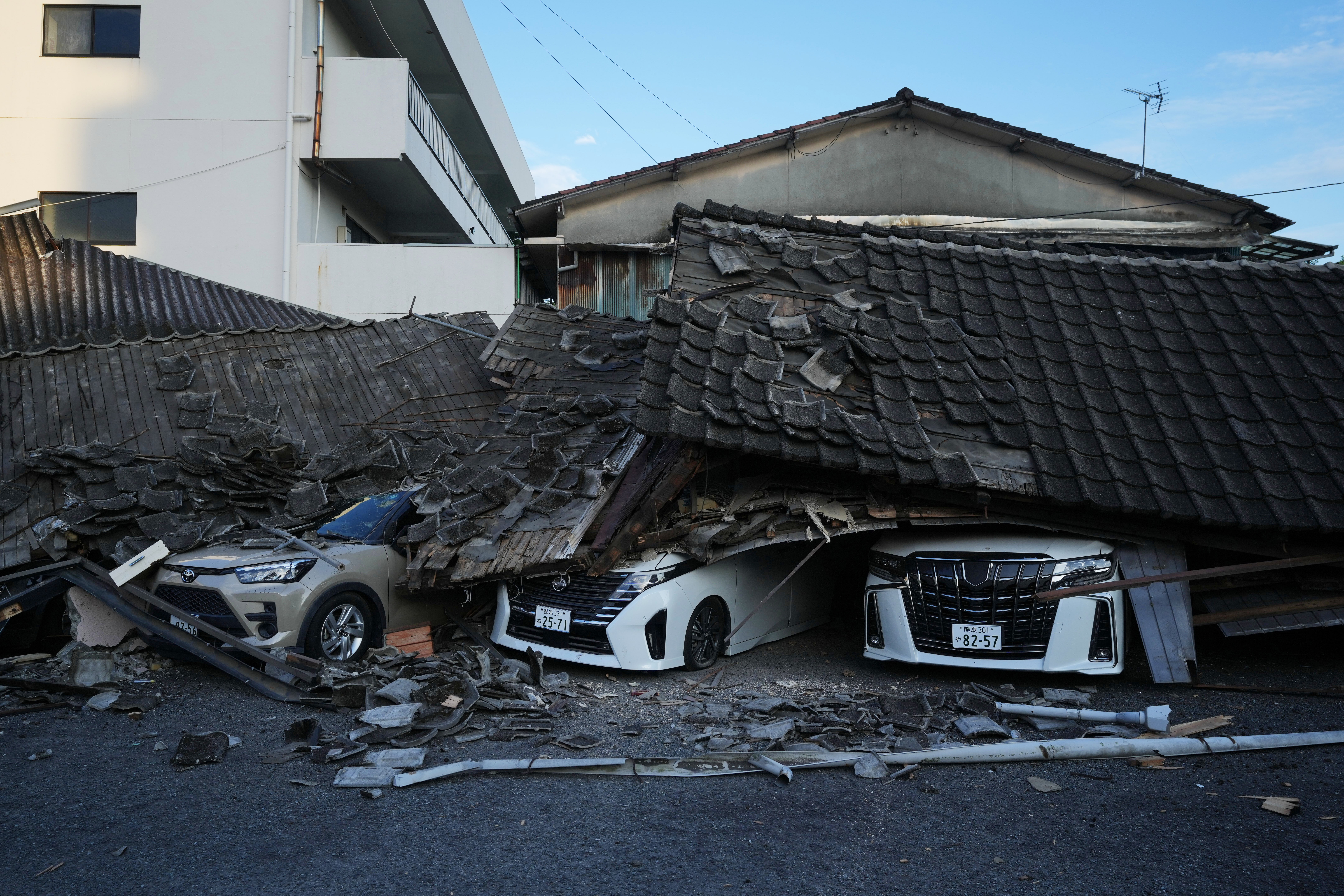 Vehicles are crushed under collapsed buildings in Yatsushiro (Copyright 2026 The Associated Press. All rights reserved)