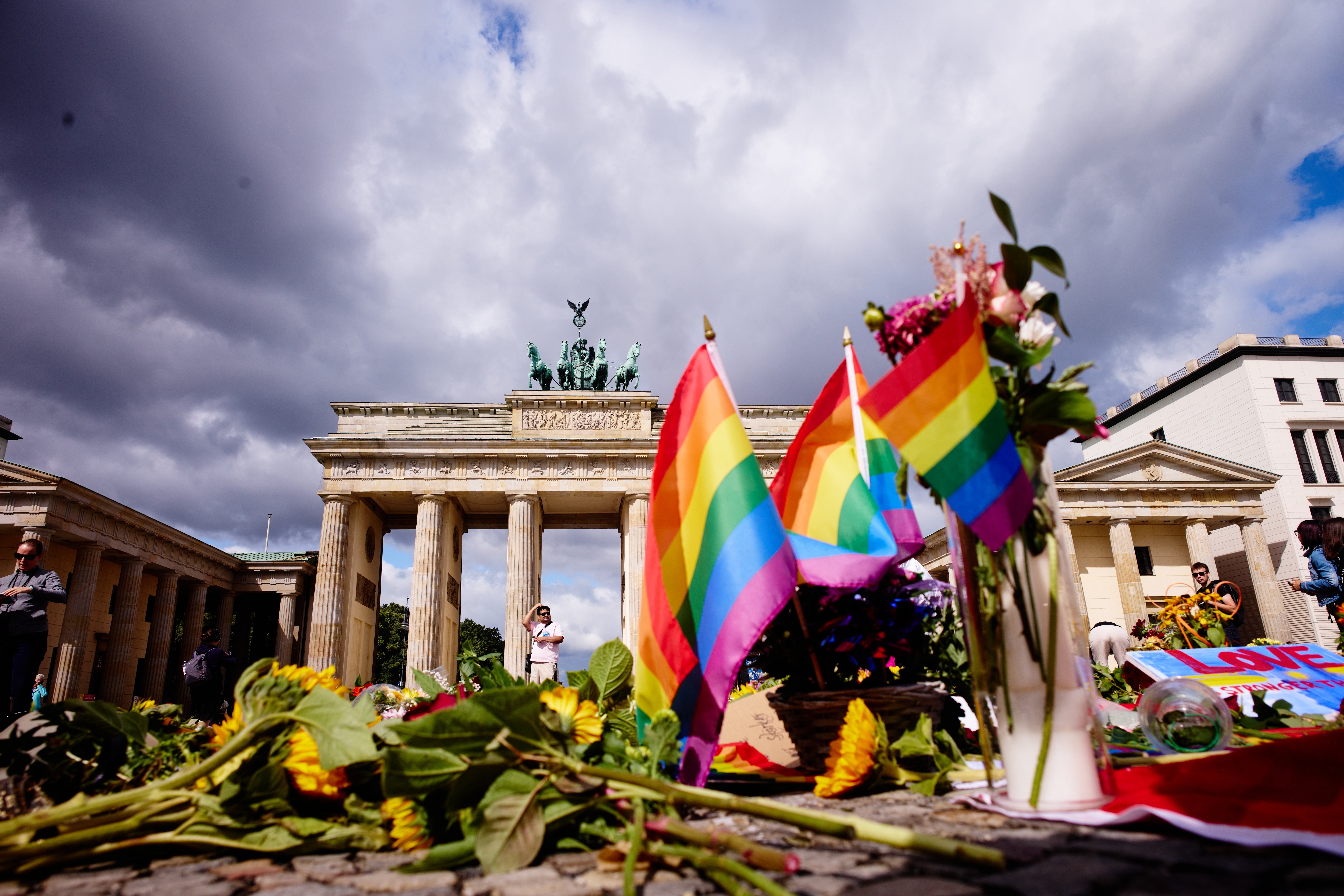 Flowers and rainbow flags placed in front of the Brandenburg Gate commemorating the victims of an attack on Saturday’s Pride March (Markus Schreiber/AP) (AP)