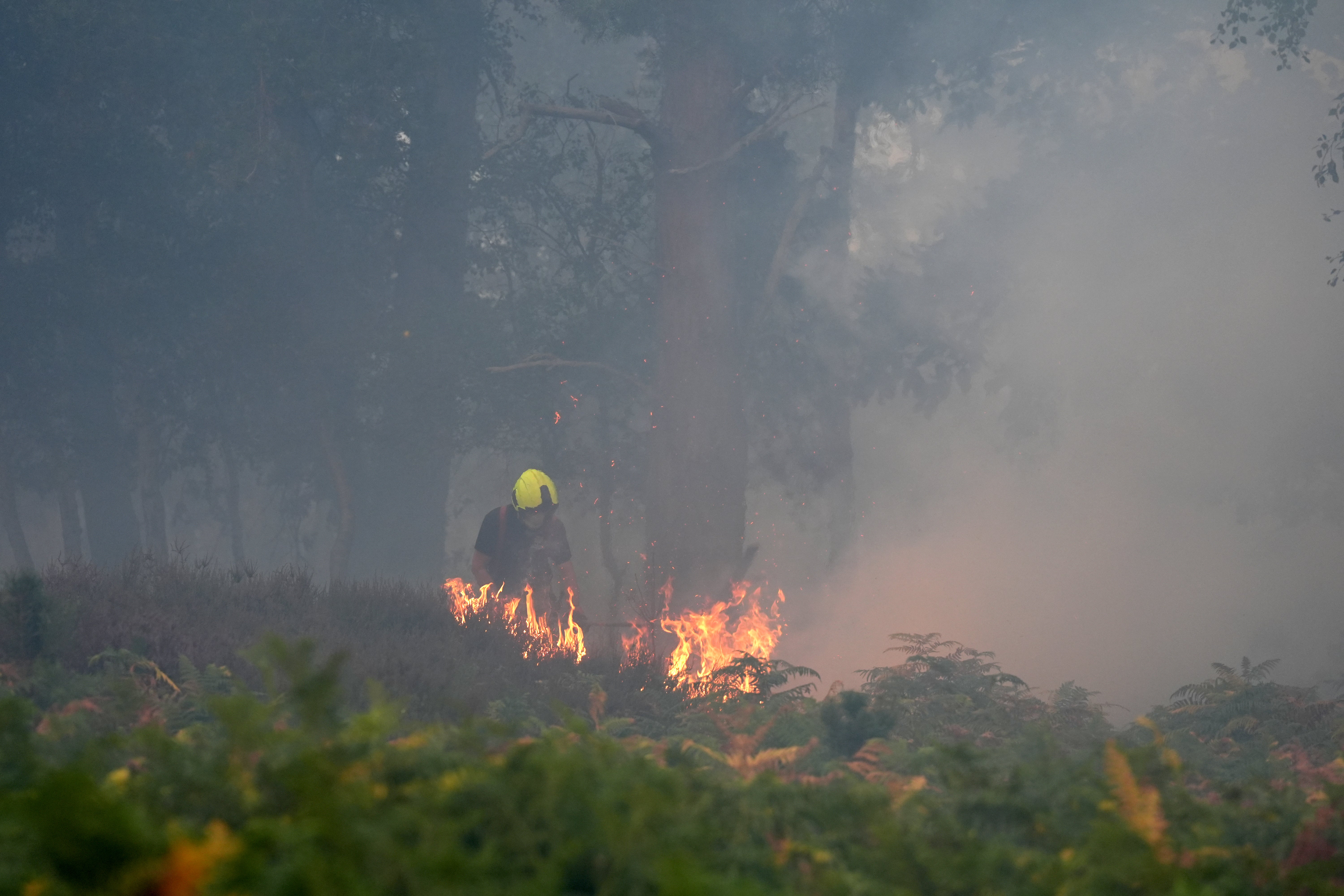 Firefighters dampen down a hotspot on Dunwich Heath (Joe Giddens/PA) (PA Wire)