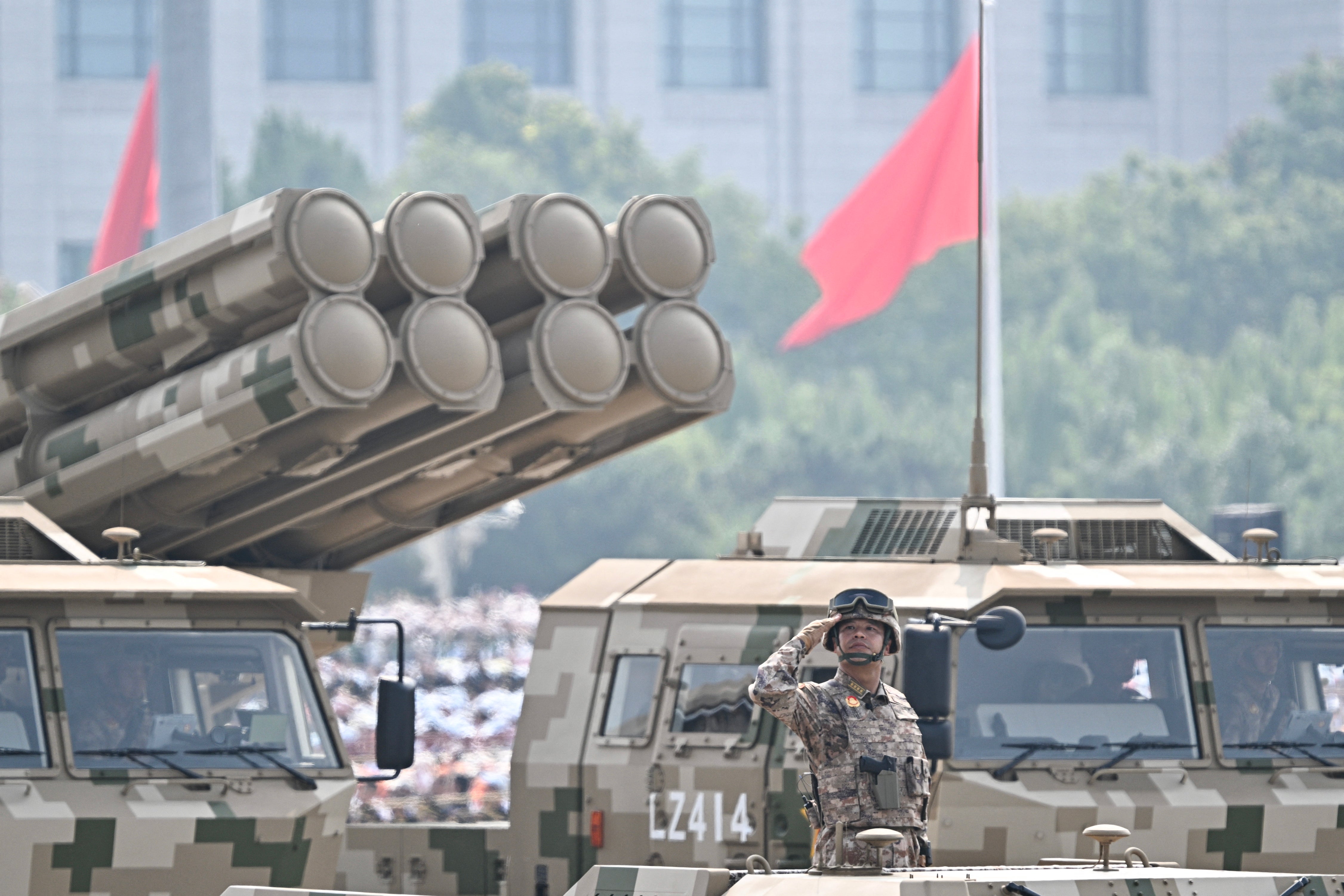 A Chinese military officer on a vehicle salutes during a military parade marking the 80th anniversary of victory over Japan and the end of World War II