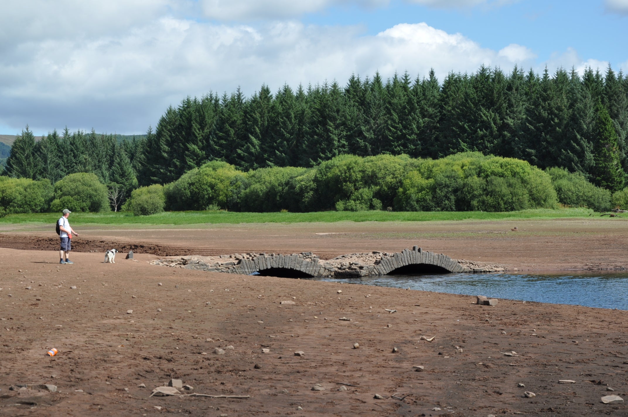 Low water levels at the Llwyn-On reservoir in South Wales reveal an old stone bridge, which was submerged during the construction of the reservoir a century ago and has made a rare appearance following a record dry spell (PA)