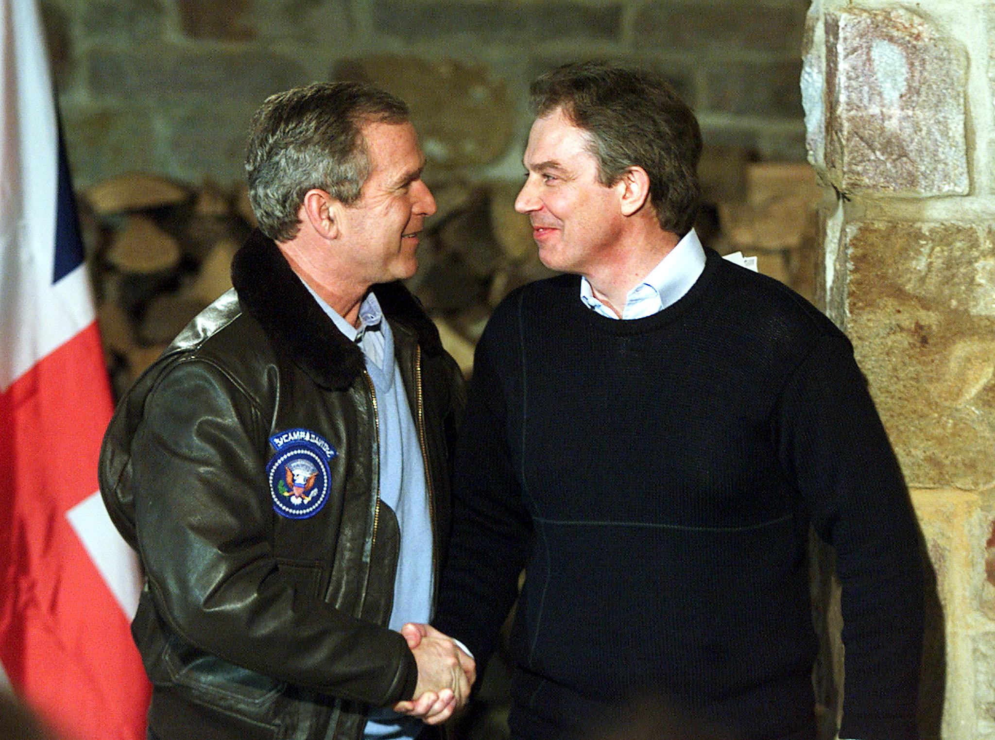 Former President George W. Bush (L) and former British Prime Minister Tony Blair shake hands after a joint press conference 23 February 2001, in Thurmont, Maryland, down the road from the presidential retreat Camp David