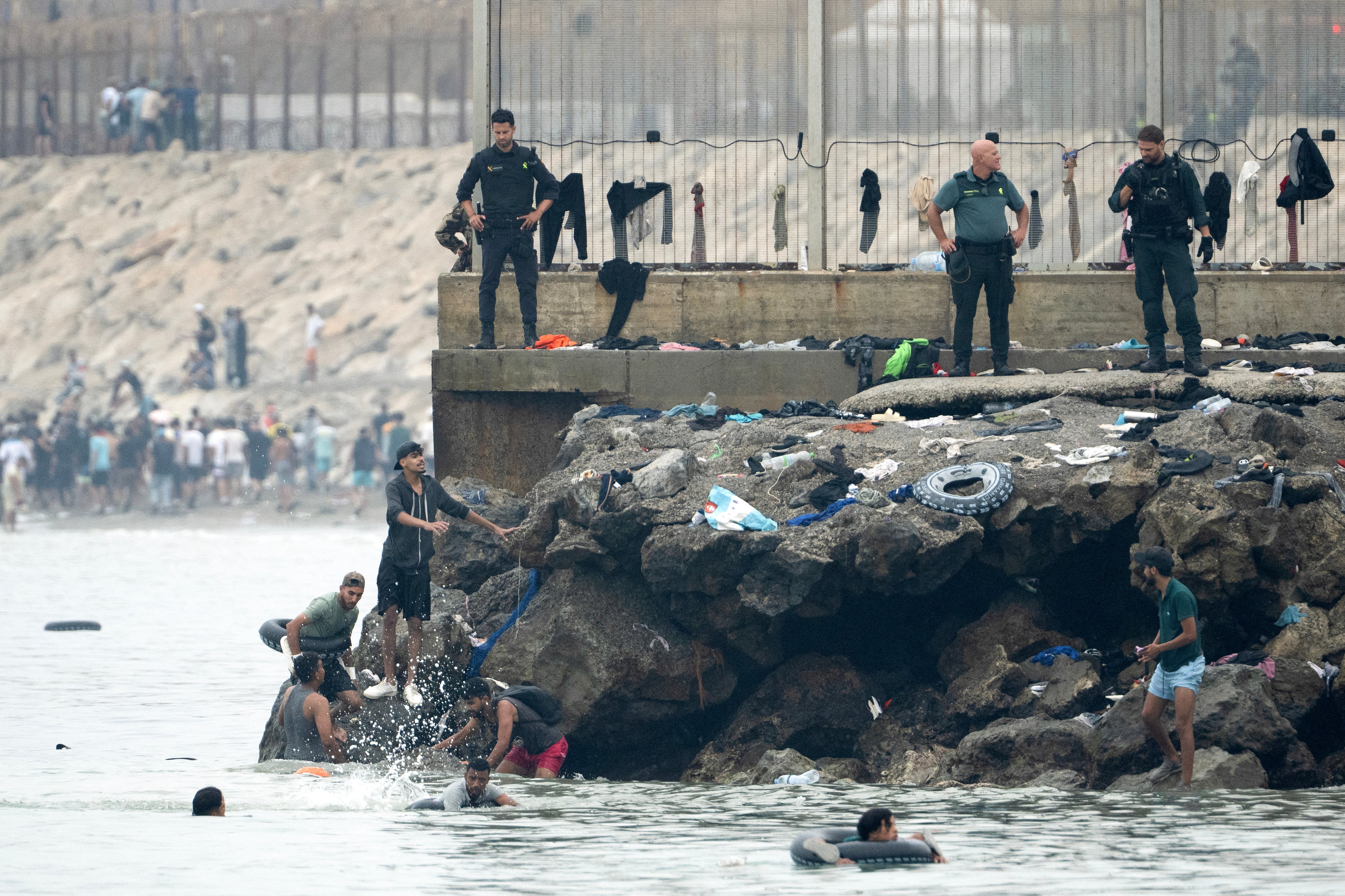 Migrants try to swim through the waters close to the border with Morocco to enter Spain's north Africa's Ceuta enclave as security forces observe on July 31, 2026. (Photo by JORGE GUERRERO / AFP via Getty Images) (AFP/Getty)