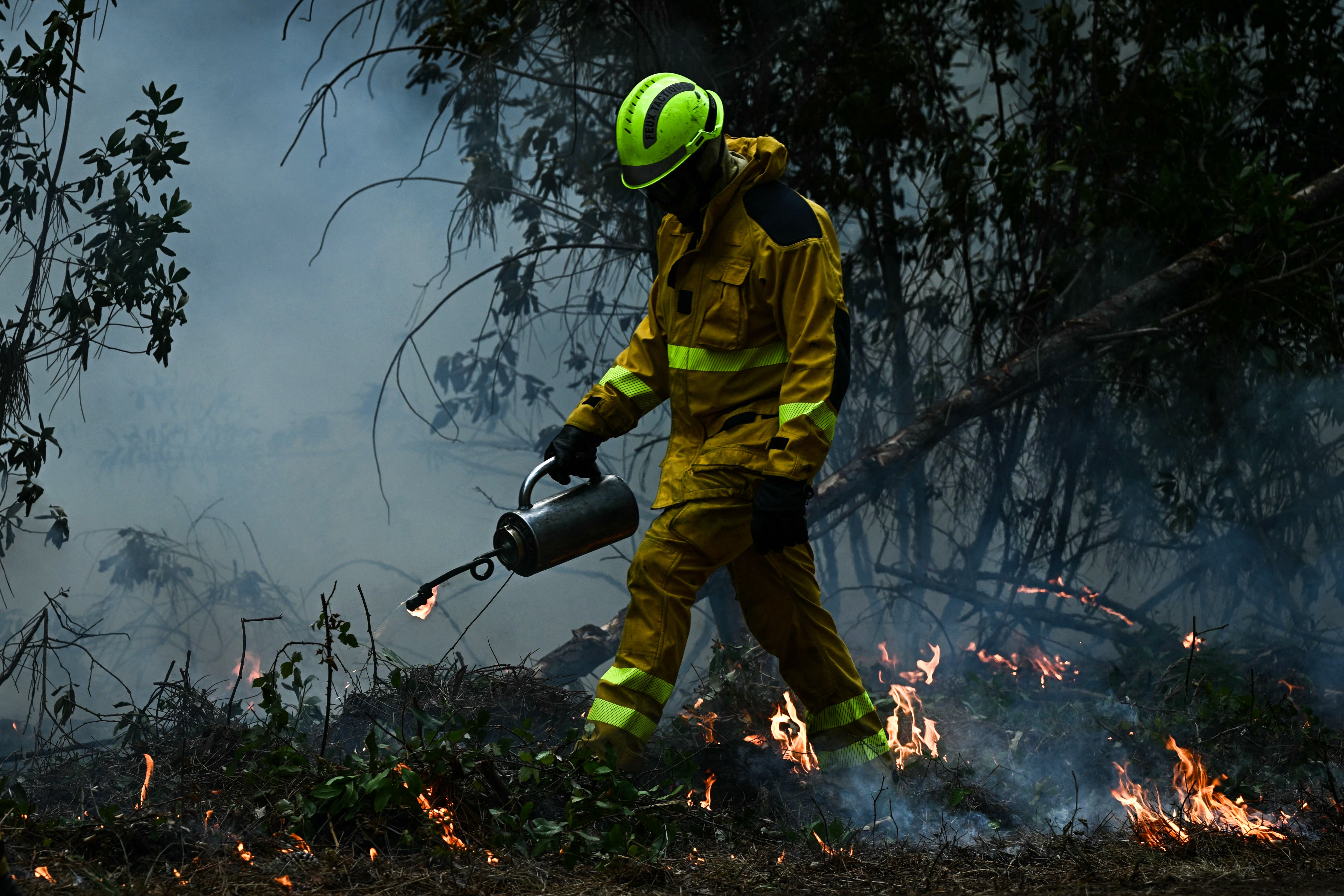A French firefighter attempts to control flames during wildfires in the Gironde region, southwestern France