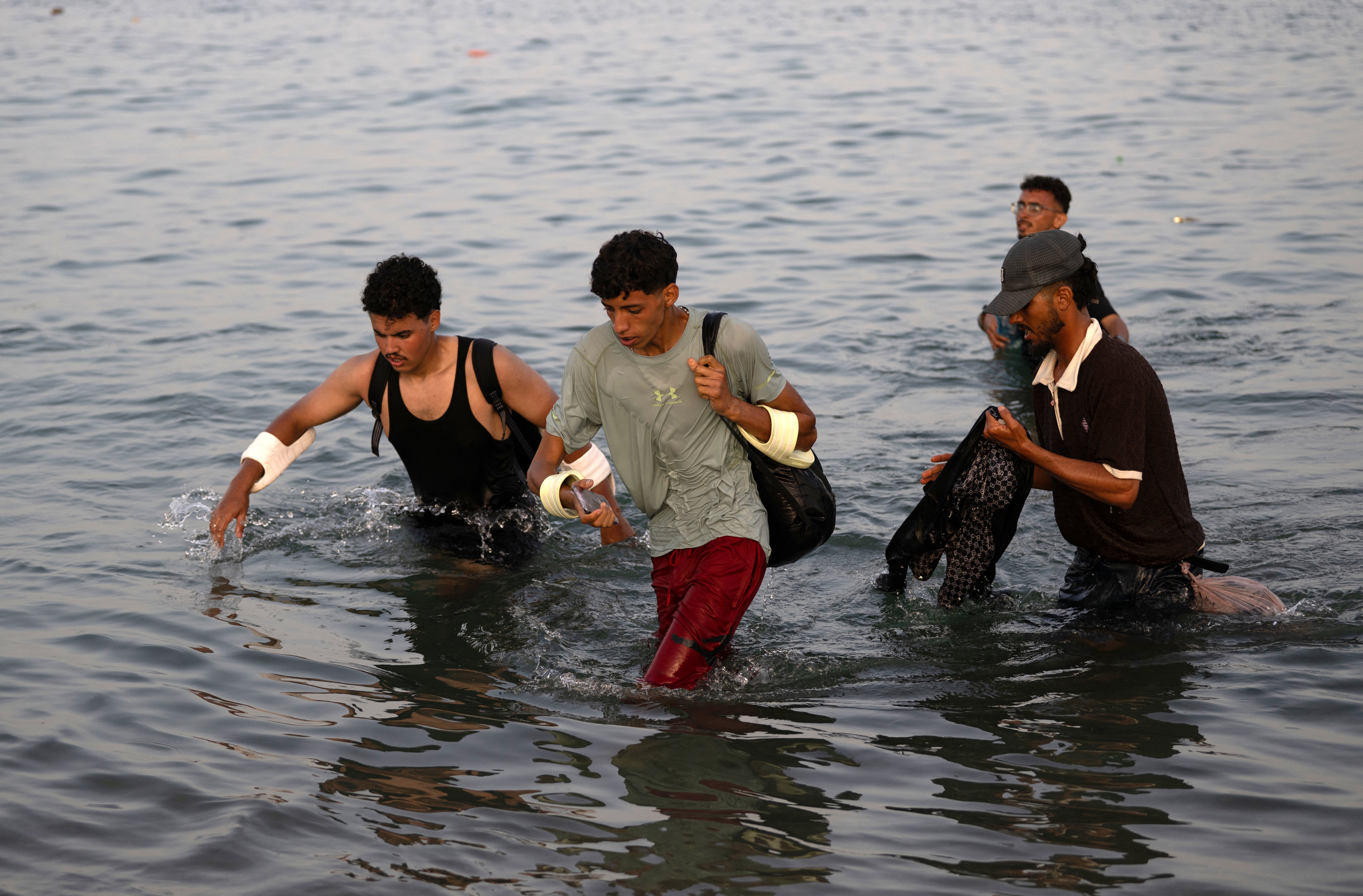 Migrants wade through the water near the border with Morocco as they attempt to enter Spain's North African enclave of Ceuta