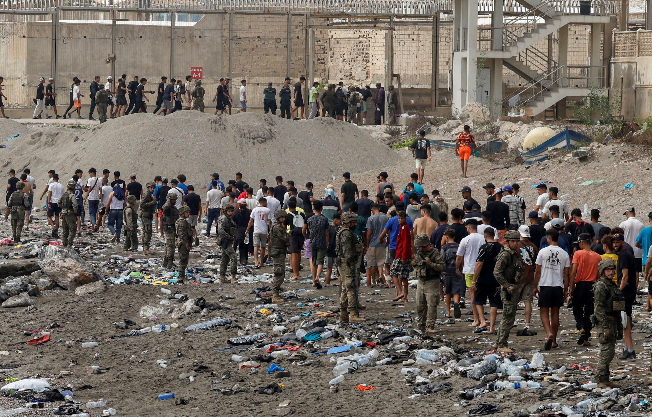People walk towards the border with Morocco leaving Spain, amid mass crossings of migrants on foot and by sea from Morocco into Spanish territory, in Ceuta
