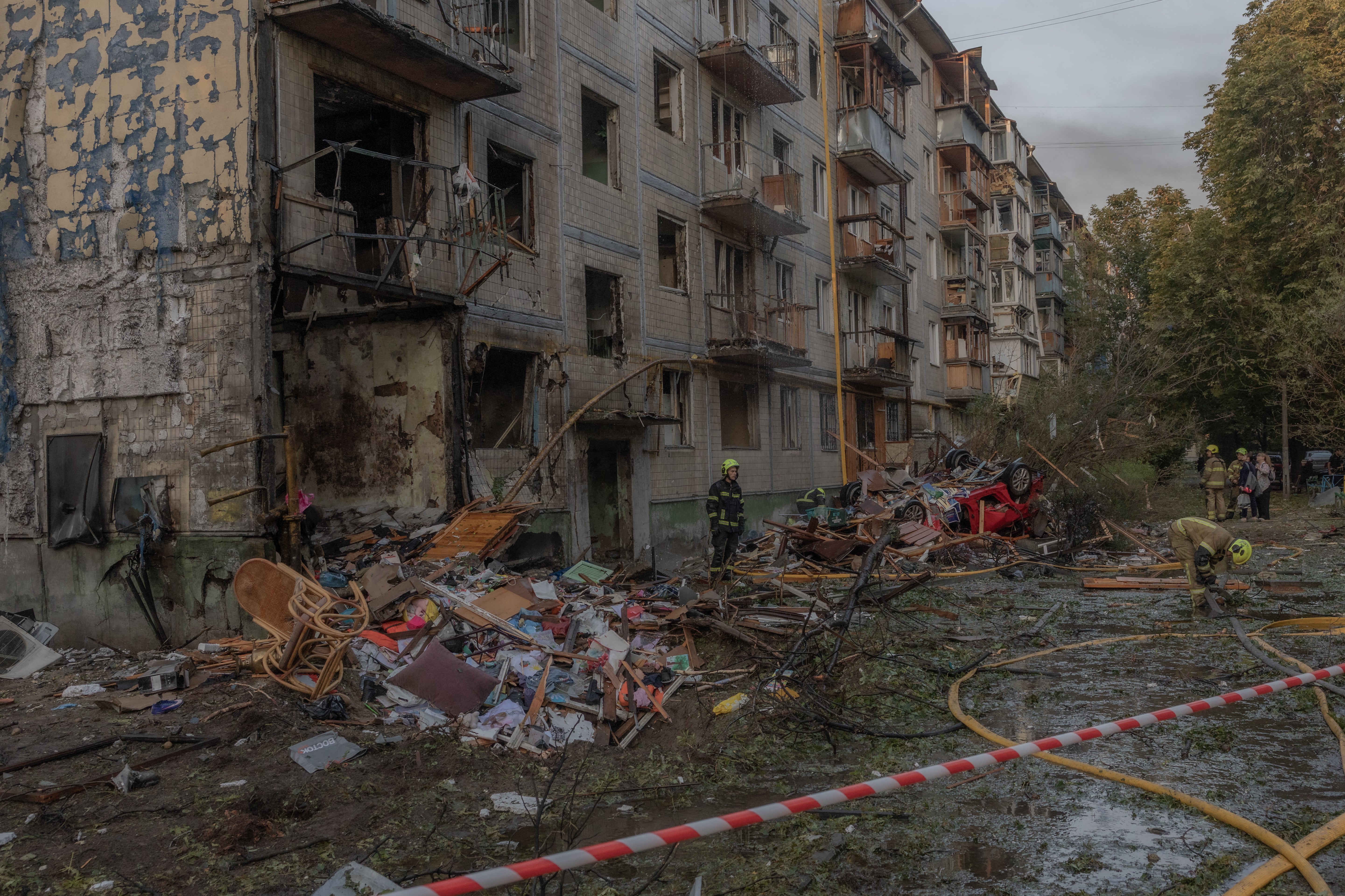 Rescuers work outside a multi-storey residential building damaged in a Russian air attack on Kyiv (AFP/Getty)