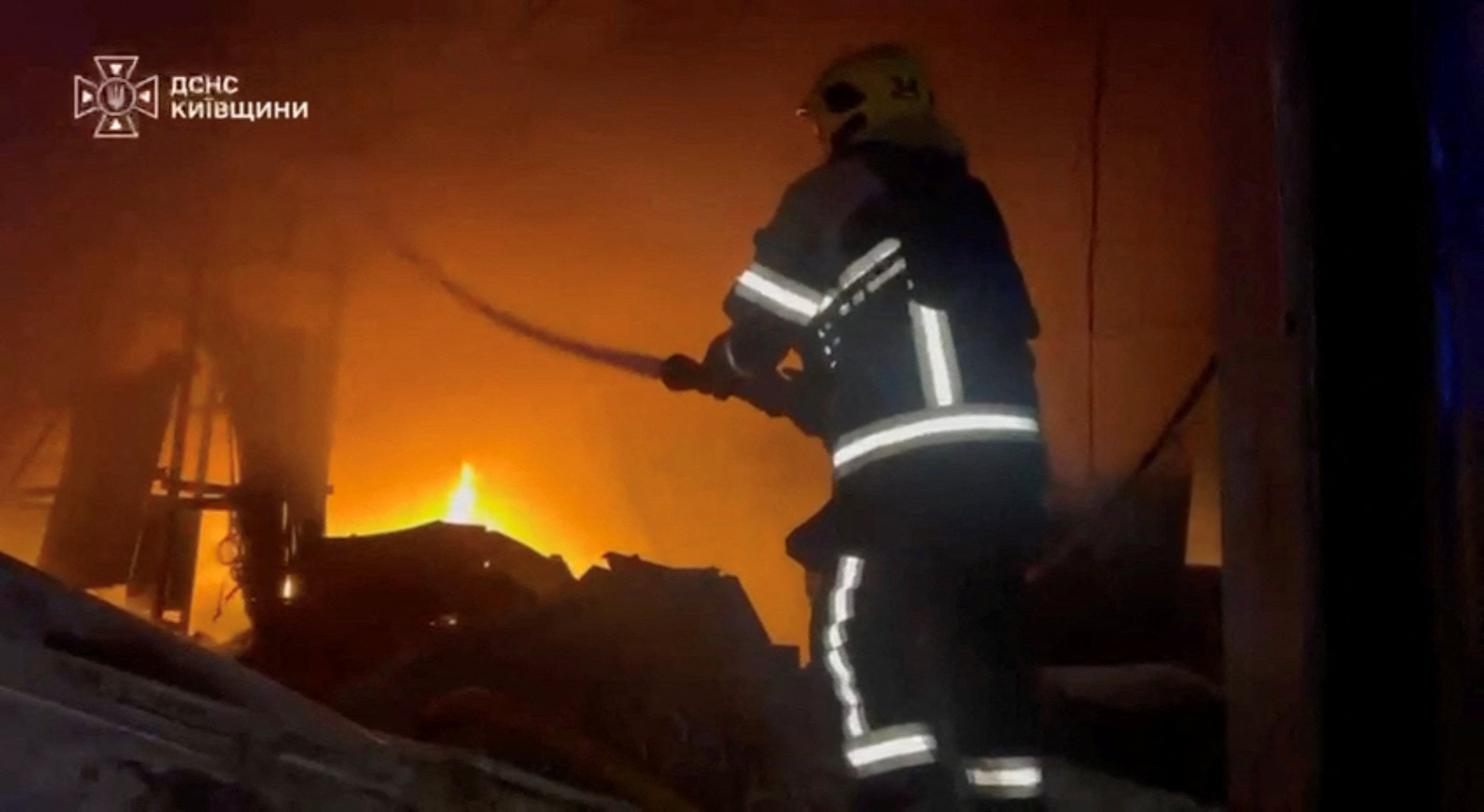 A rescuer works at the site of a fire in a warehouse at a location given as Bucha District, Kyiv Region, Ukraine, in this still image obtained from a video released on August (Reuters)