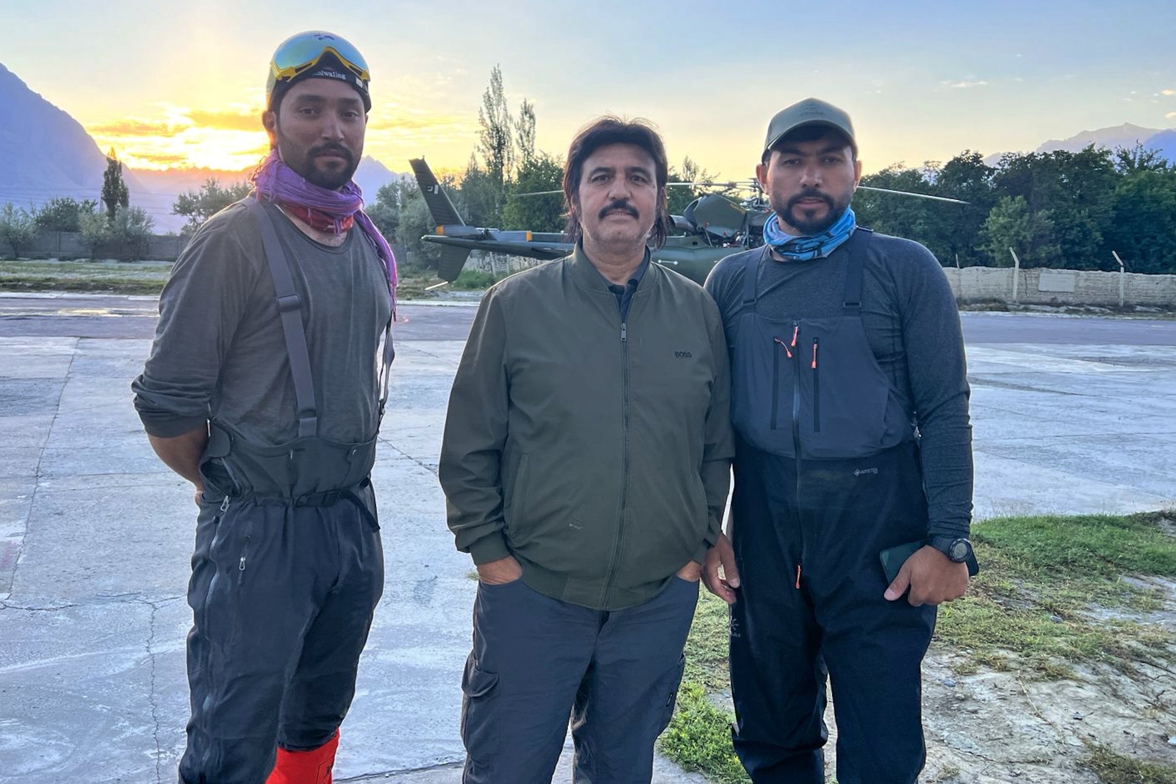 Members of a mountaineers rescue team pose for photo with honorary general secretary of Alpine Club of Pakistan Ayaz Ahmed Shigri, center, before departing from an airbase on a search operation for climbers missing after an avalanche on Pakistan's Broad Peak, in Skardu (AP)