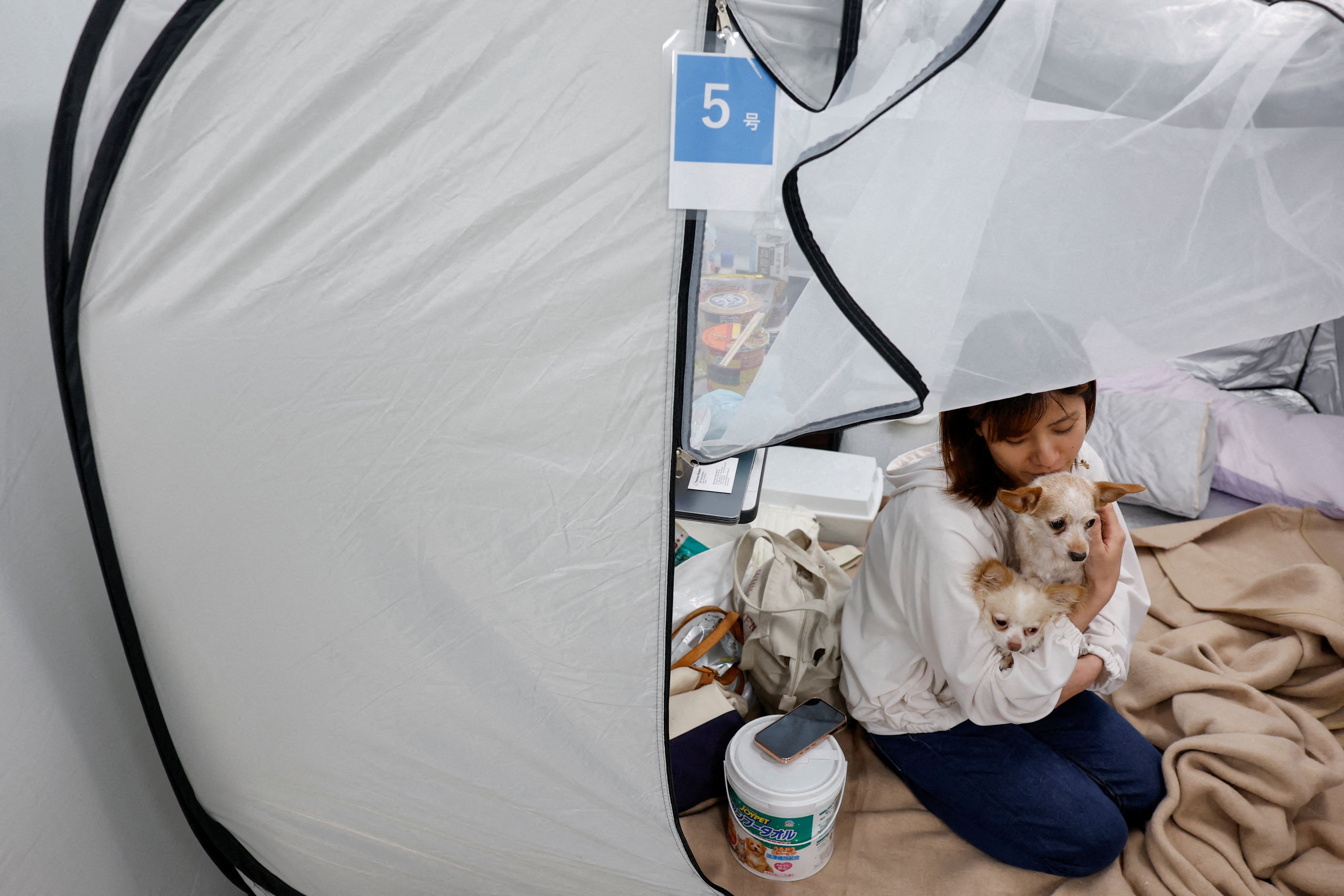 Tomoko Takaoka, 31, who evacuated from Uki with her pet dogs Chihuahua Ku (7) and Chihuahua mixed with poodle Sheri (8) (Reuters)