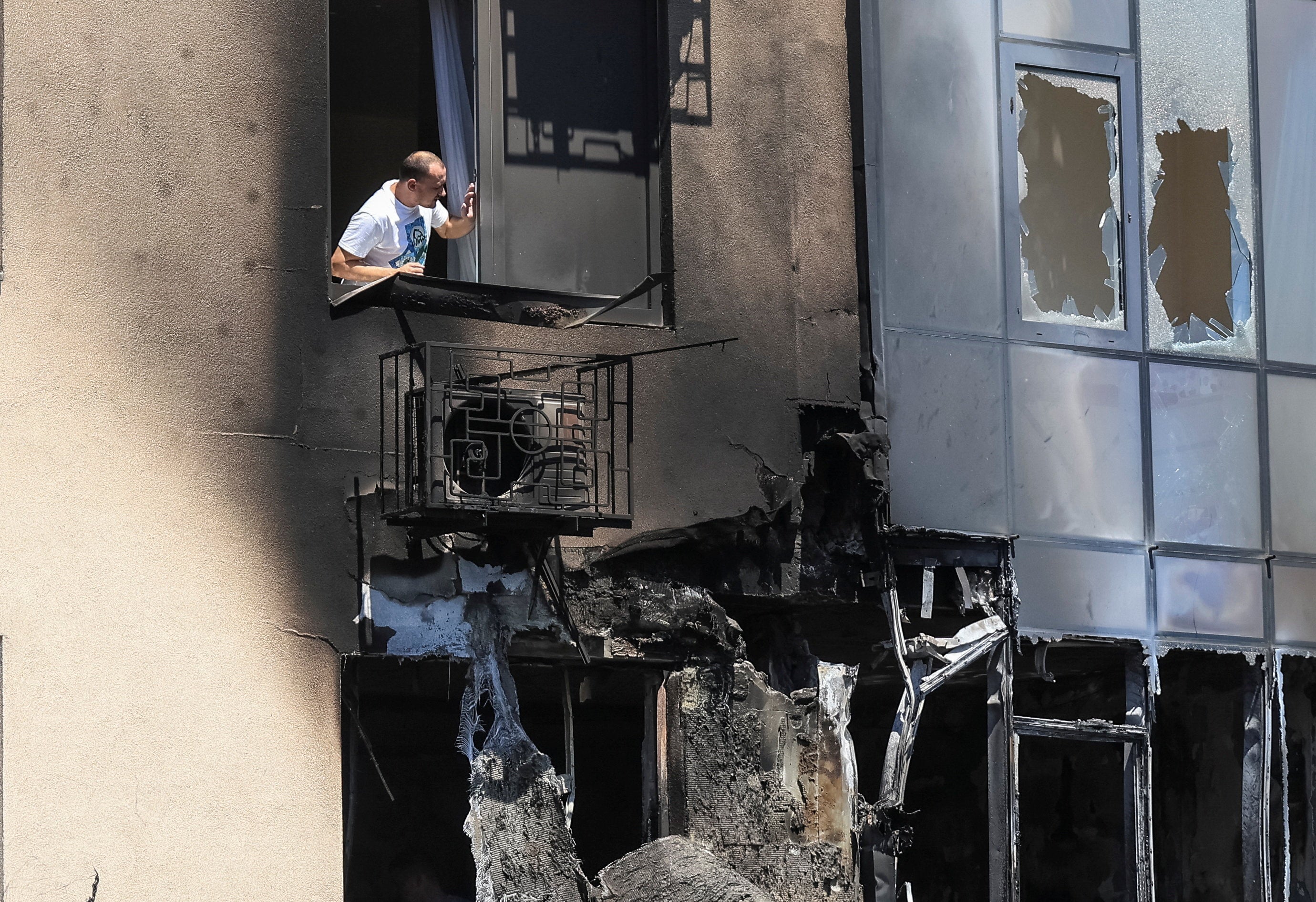 A resident looks out of a window of an apartment building damaged by a Russian drone strike, amid Russia's attack on Ukraine, in Odesa, Ukraine (Reuters)