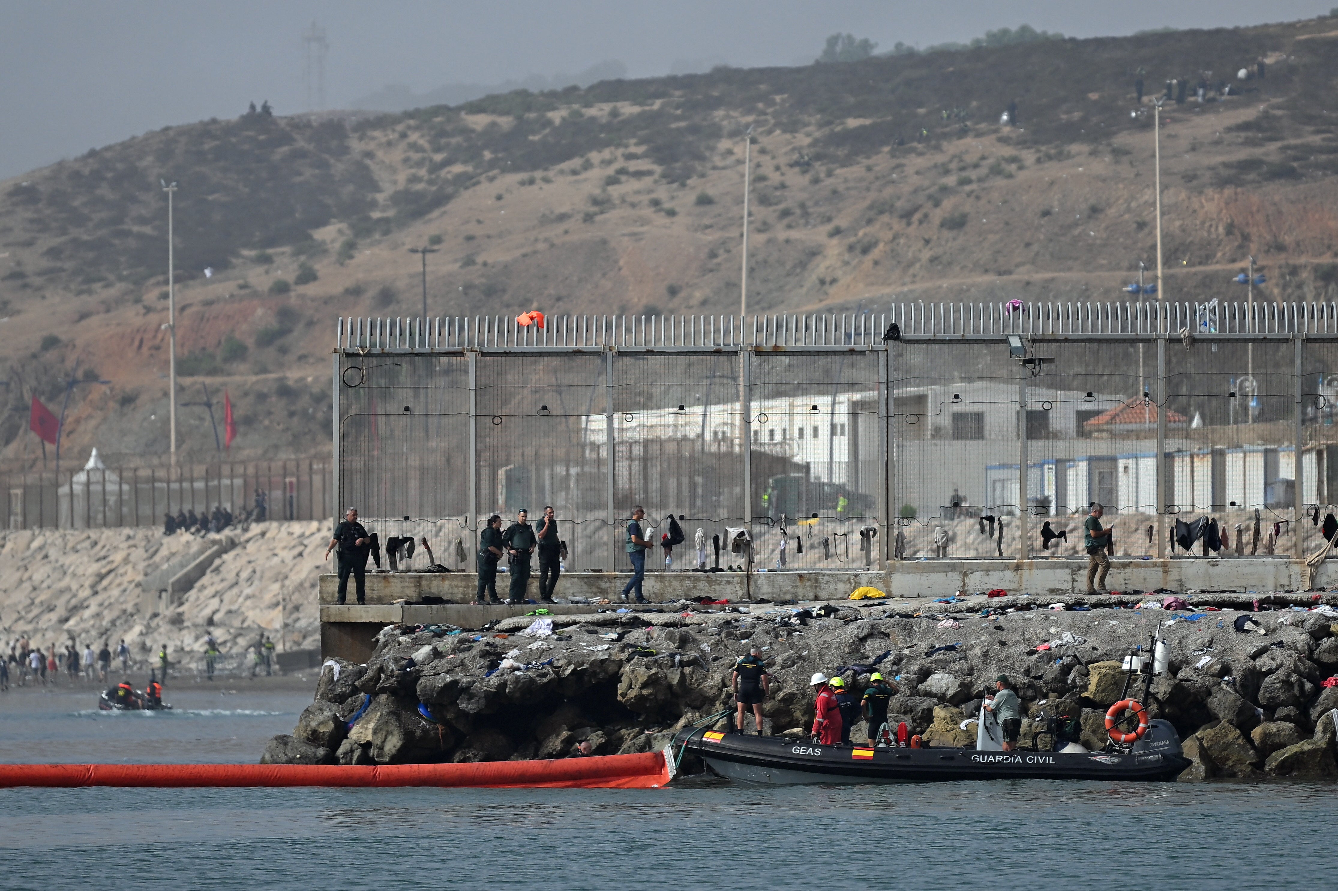 A 1,640 feet pneumatic barrier is deployed in the water by a Spanish Guardia Civil boat near the border post to reinforce security