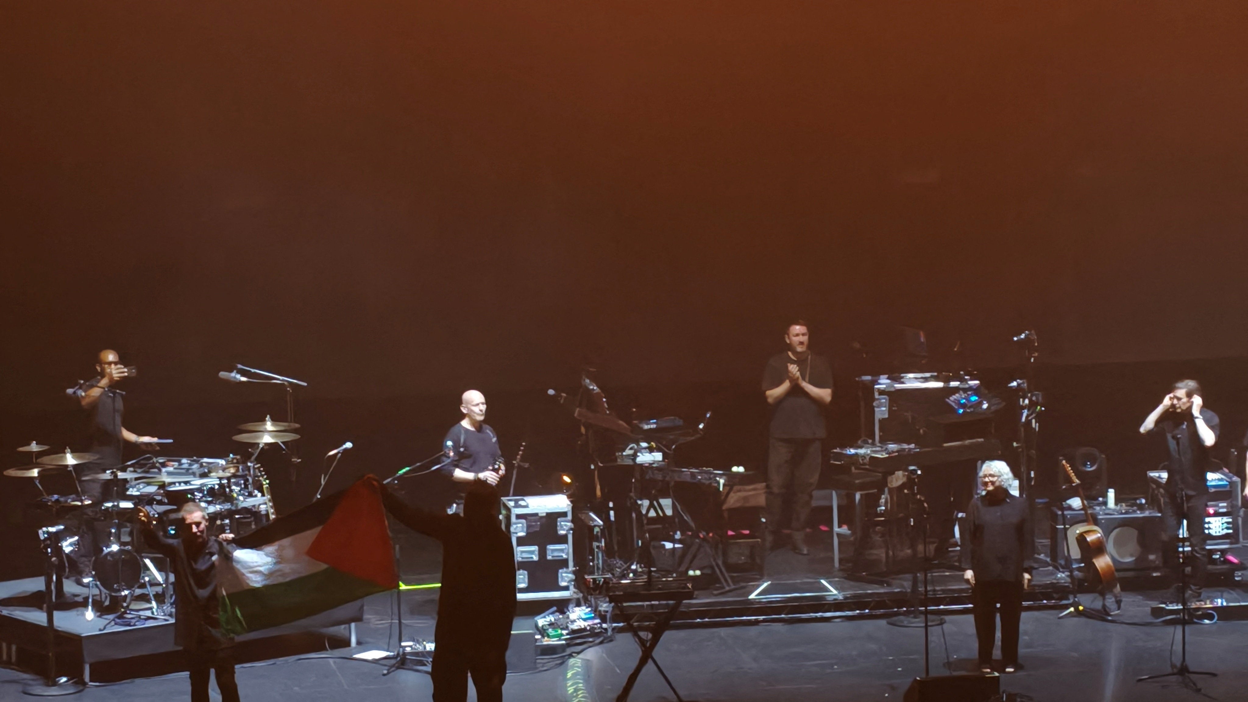 Massive Attack band members hold up a Palestinian flag during their Singapore concert (Reuters)