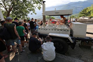 People line up for hot meals at a field kitchen set up by the local authorities in the settlement of Massandra, Crimea
