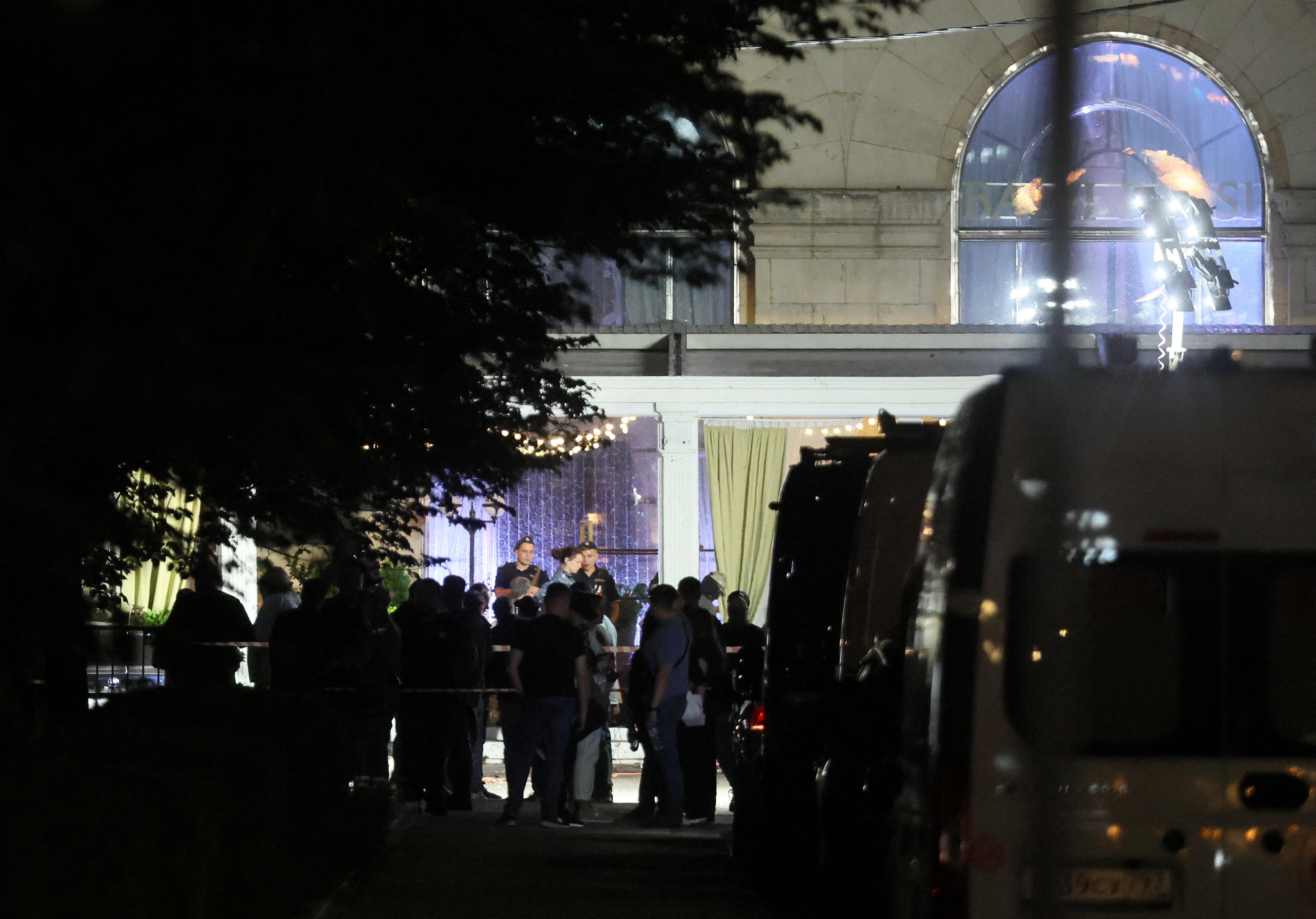 Law enforcement officers and emergency services personnel work at the site of an explosion at a restaurant in central Moscow