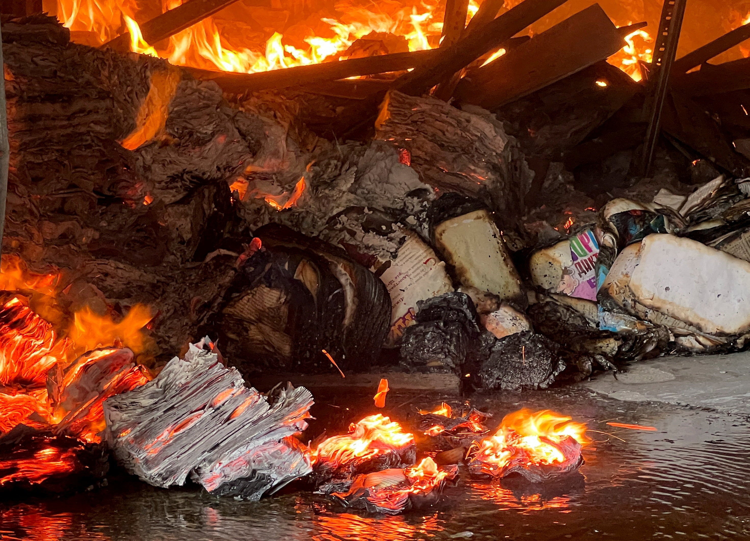 Books burn at the site of a book warehouse hit by a Russian drone strike, amid Russia's attack on Ukraine, in Kharkiv, Ukraine