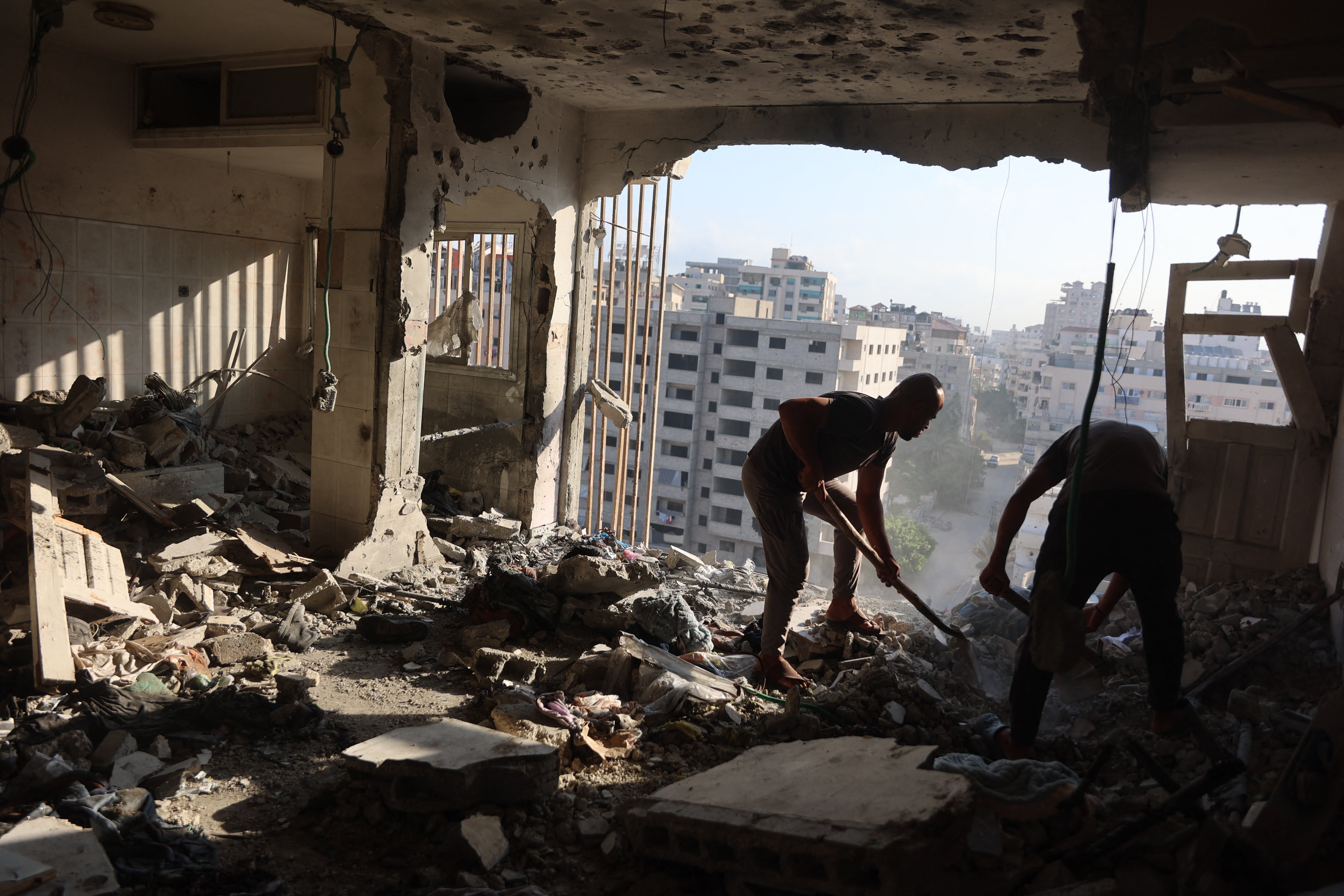 Palestinian residential salvage what they can from an apartment targeted in overnight Israeli airstrikes (AFP/Getty)
