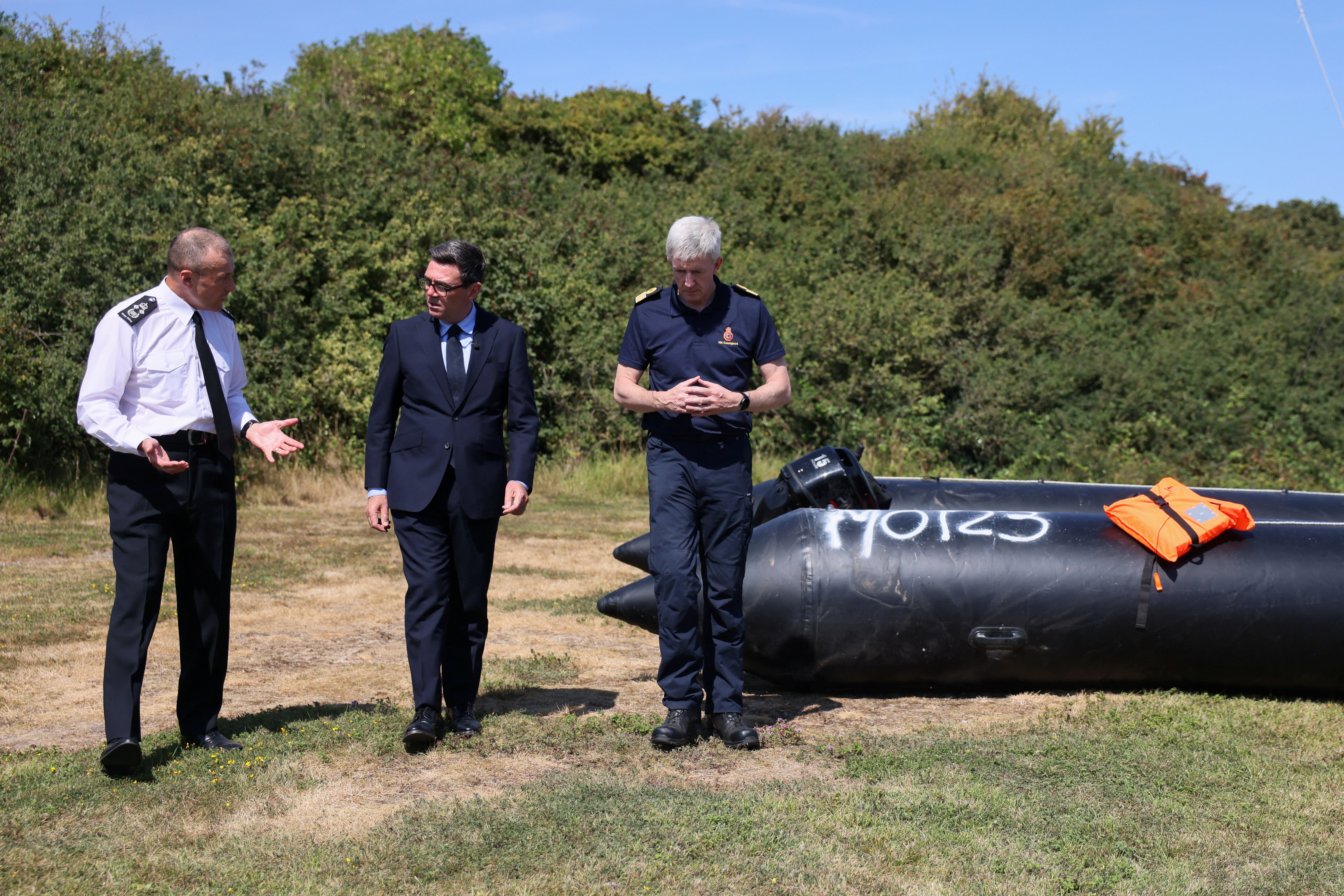 Prime Minister Andy Burnham speaks with John Craig, Interim Chief Coastguard, and Duncan Capps, Border Security Commander (DG BSC), near a recovered small boat (Jack Taylor/PA) (PA Wire)