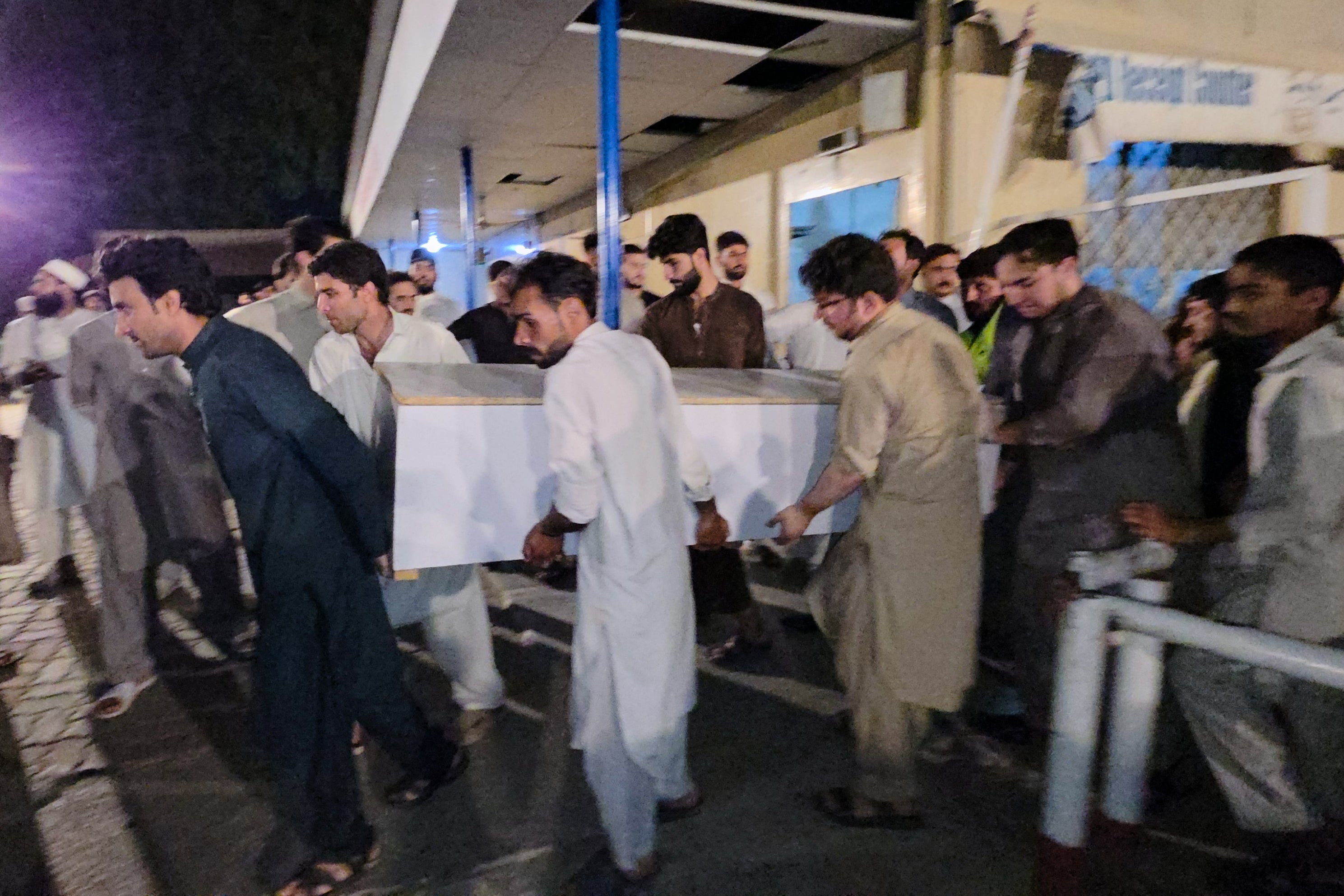 People carry a casket of a victim of suicide bombing, to transport after collecting from a hospital