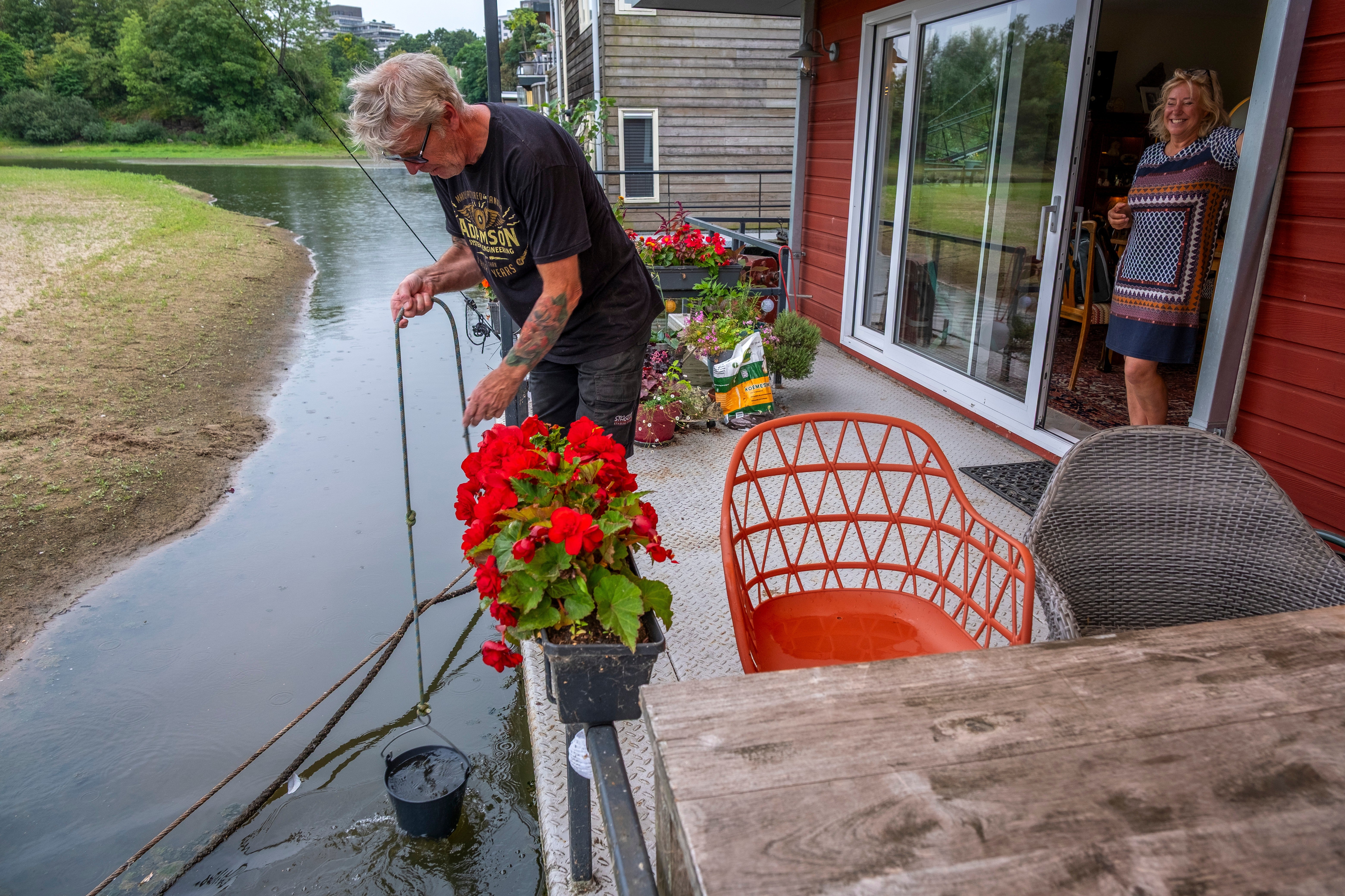 Houseboat owners pull up water for plants from the Waal river in Nijmegen
