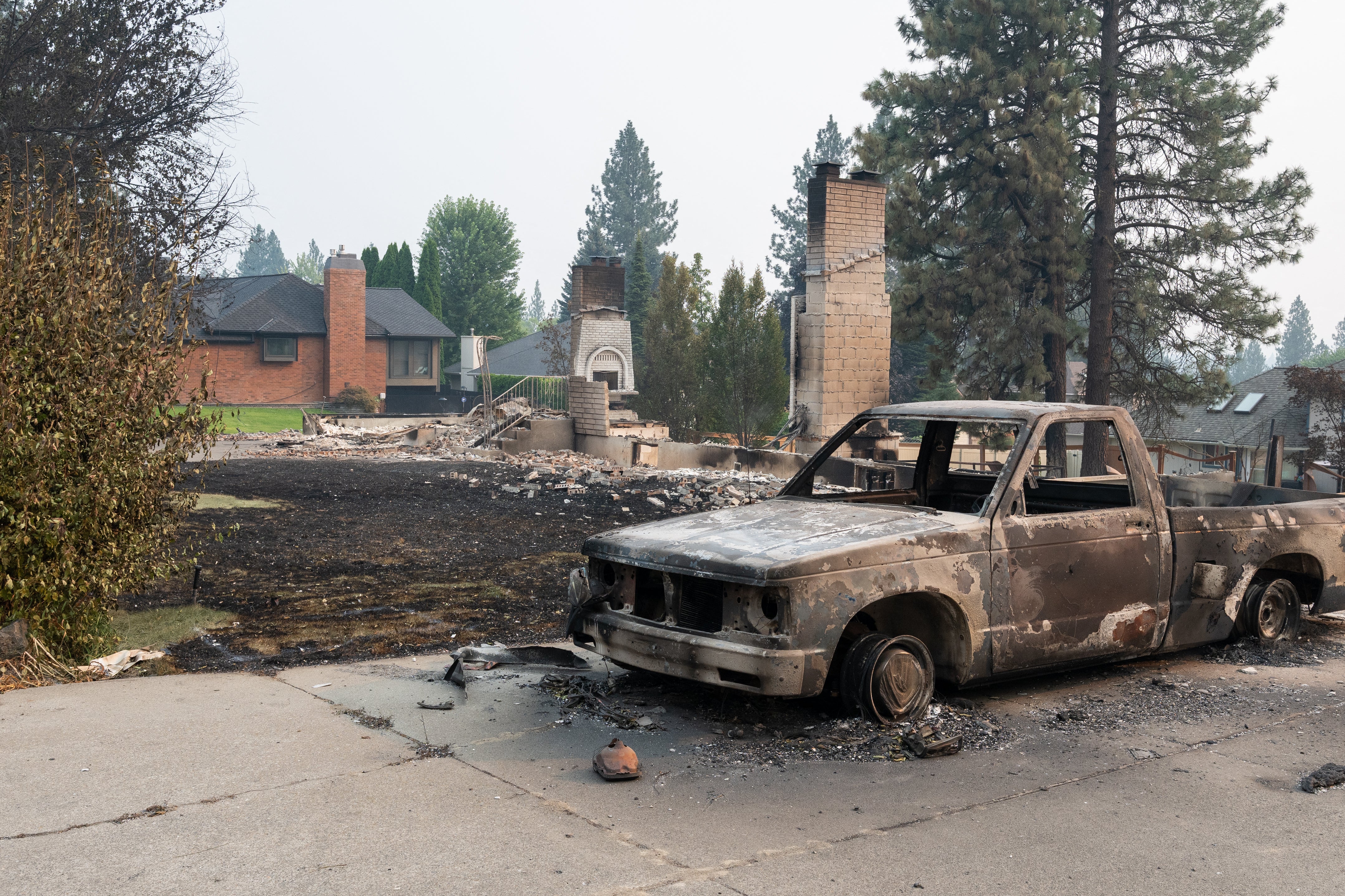 A burned out pickup truck sits in the driveway of what was once a residential home in Balboa