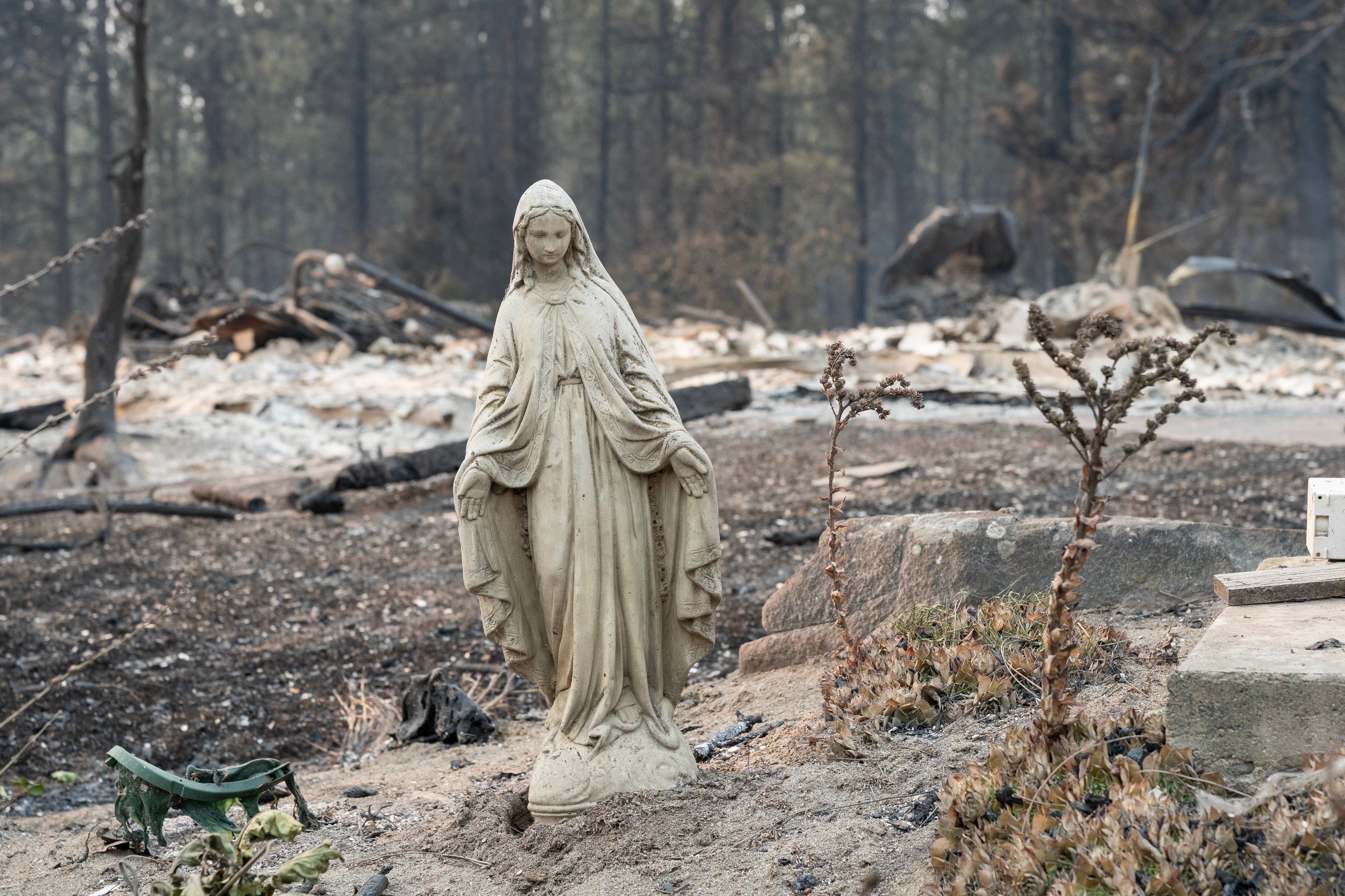 An untouched statue of the Virgin Mary is all that remains of a property in Spokane’s Balboa neighborhood after this weekend’s fast-moving wildfires