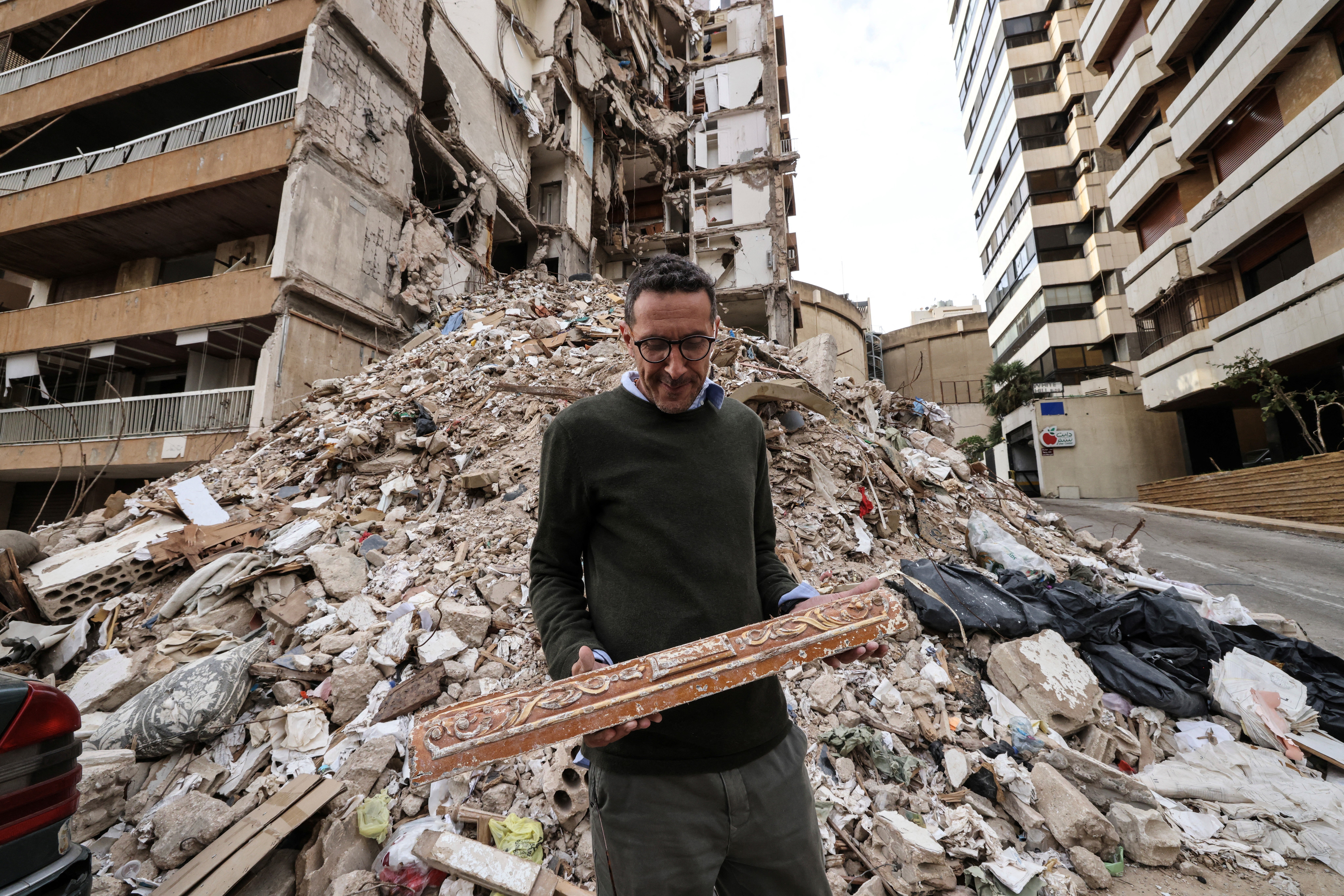 Wael Sabbagh, who lost his mother and brother when their house in Beirut's Tallet el-Khayat, an affluent residential neighborhood was struck by an Israeli strike in April, looks at debris in front of the remains of the building on May 18, 2026 (AFP/Getty)