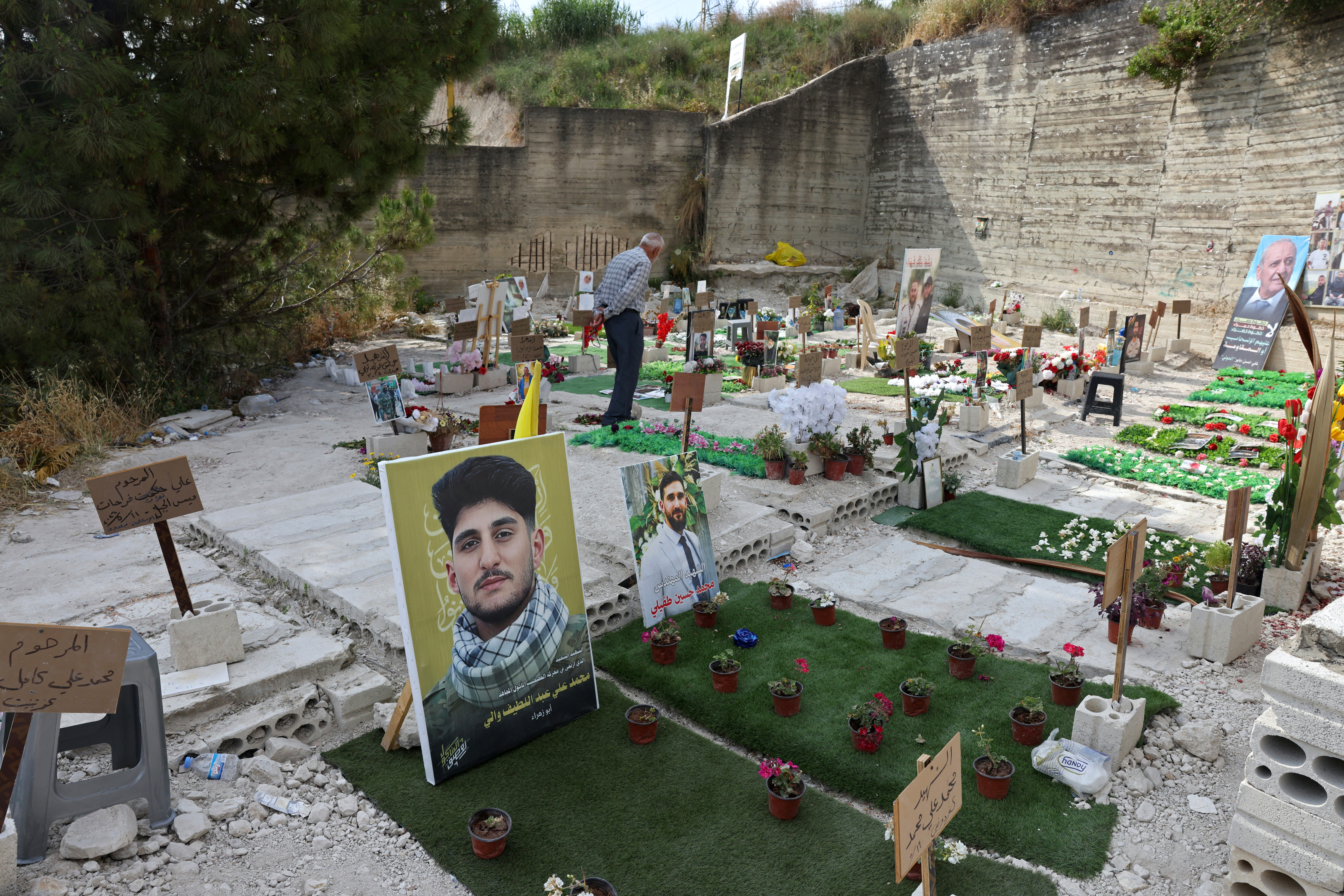 A man walks inside a temporary cemetery built for Hezbollah fighters and civilians killed during the ongoing war, in the southern coastal Lebanese city of Sidon on June 11 (AFP/Getty)