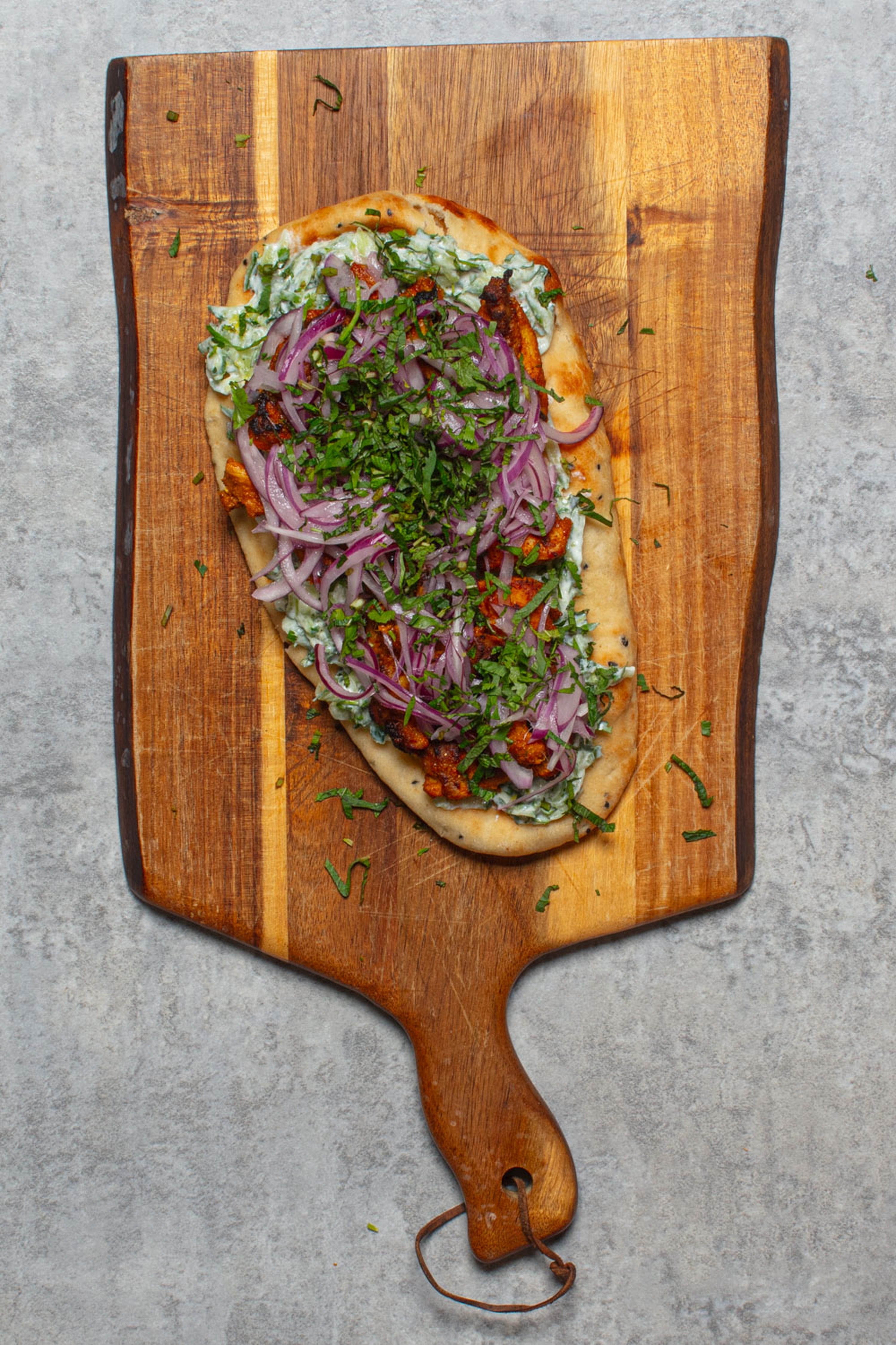 Tandoori chicken, cooling cucumber yoghurt and pickled onions piled onto warm naan