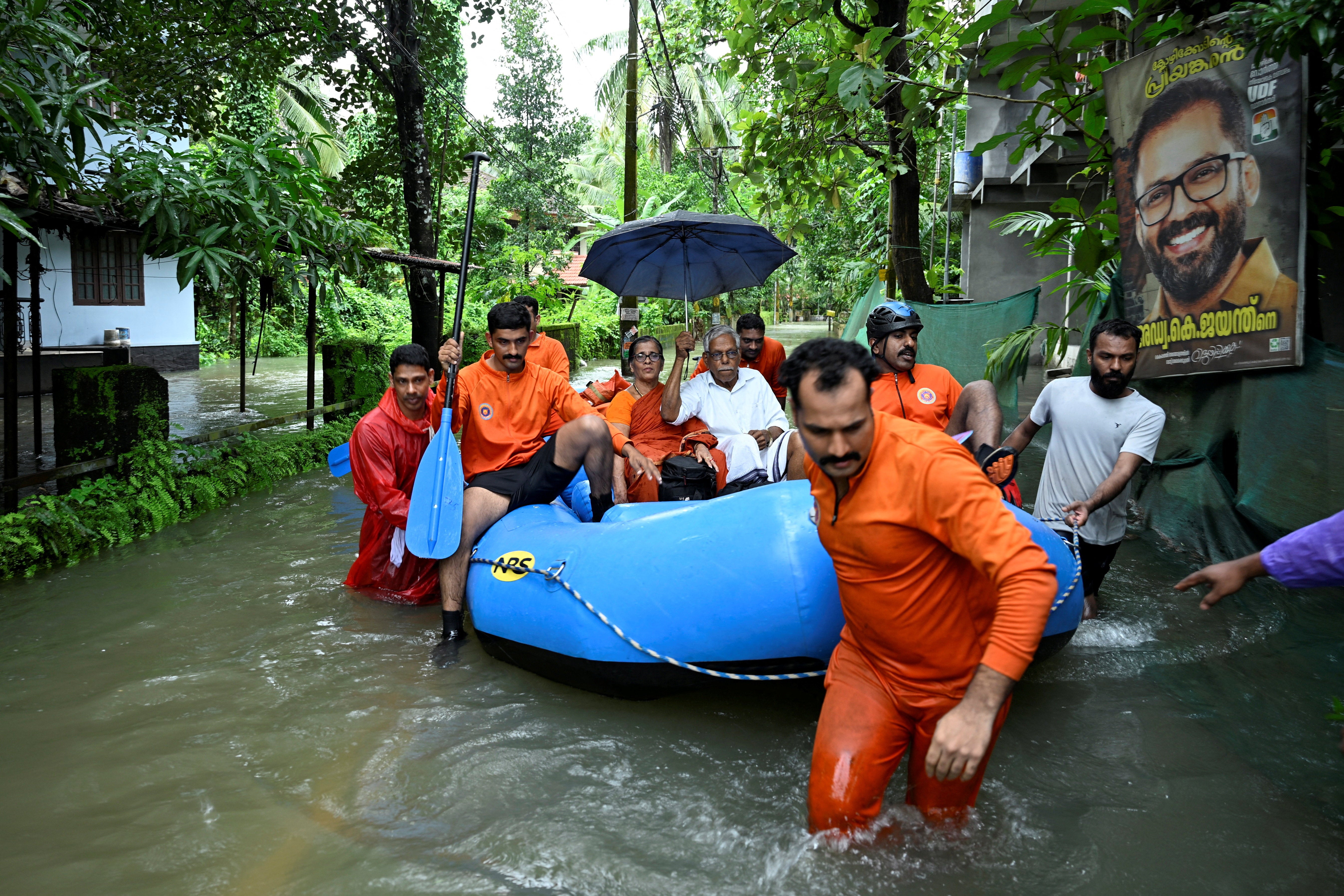 Rescue personnel move residents from a flooded neighbourhood following heavy rain in Kakkodi, Kerala, India
