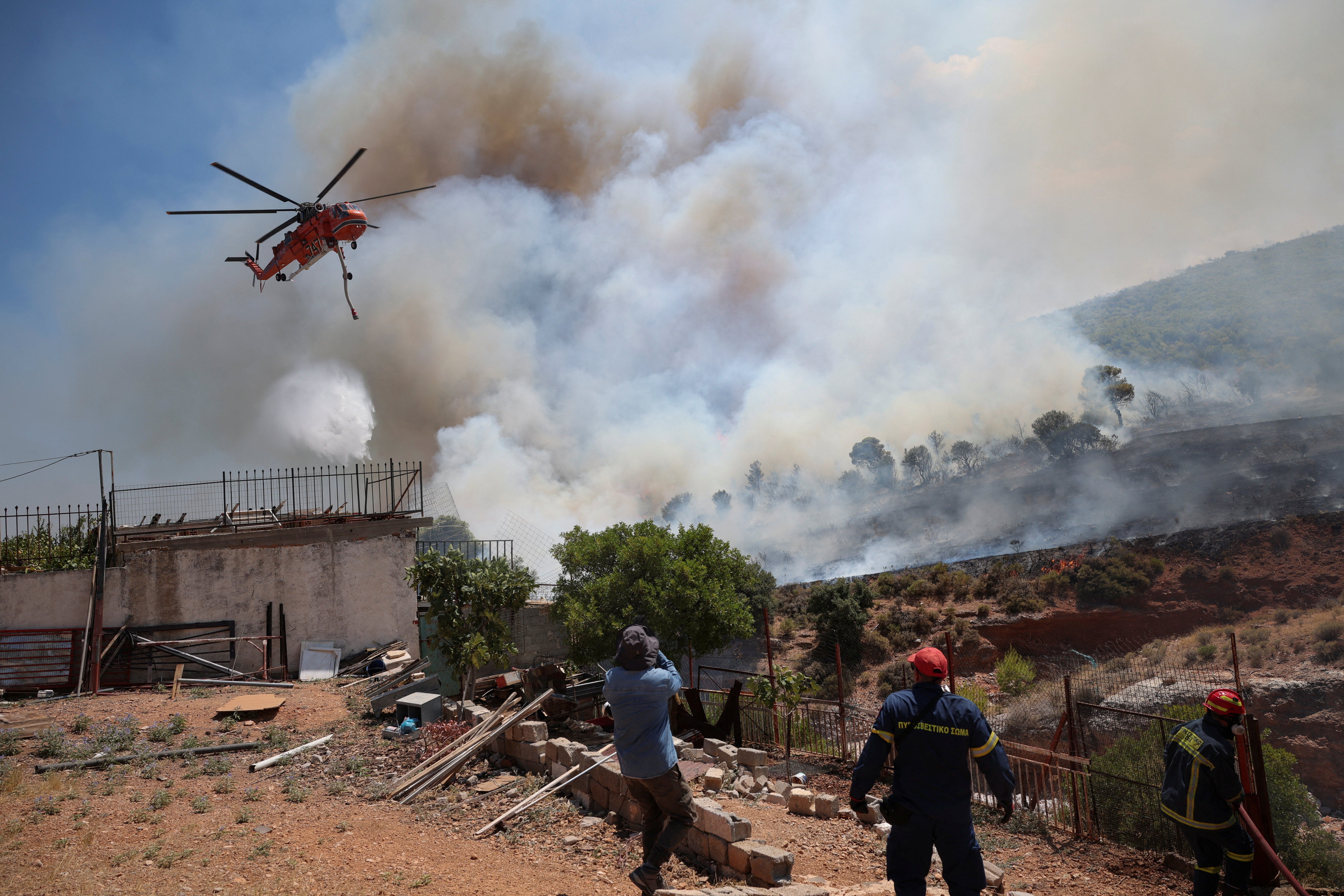 A firefighting helicopter operates as firefighters try to extinguish a wildfire in Vlychada, west of Athens, Greece, August 3, 2026