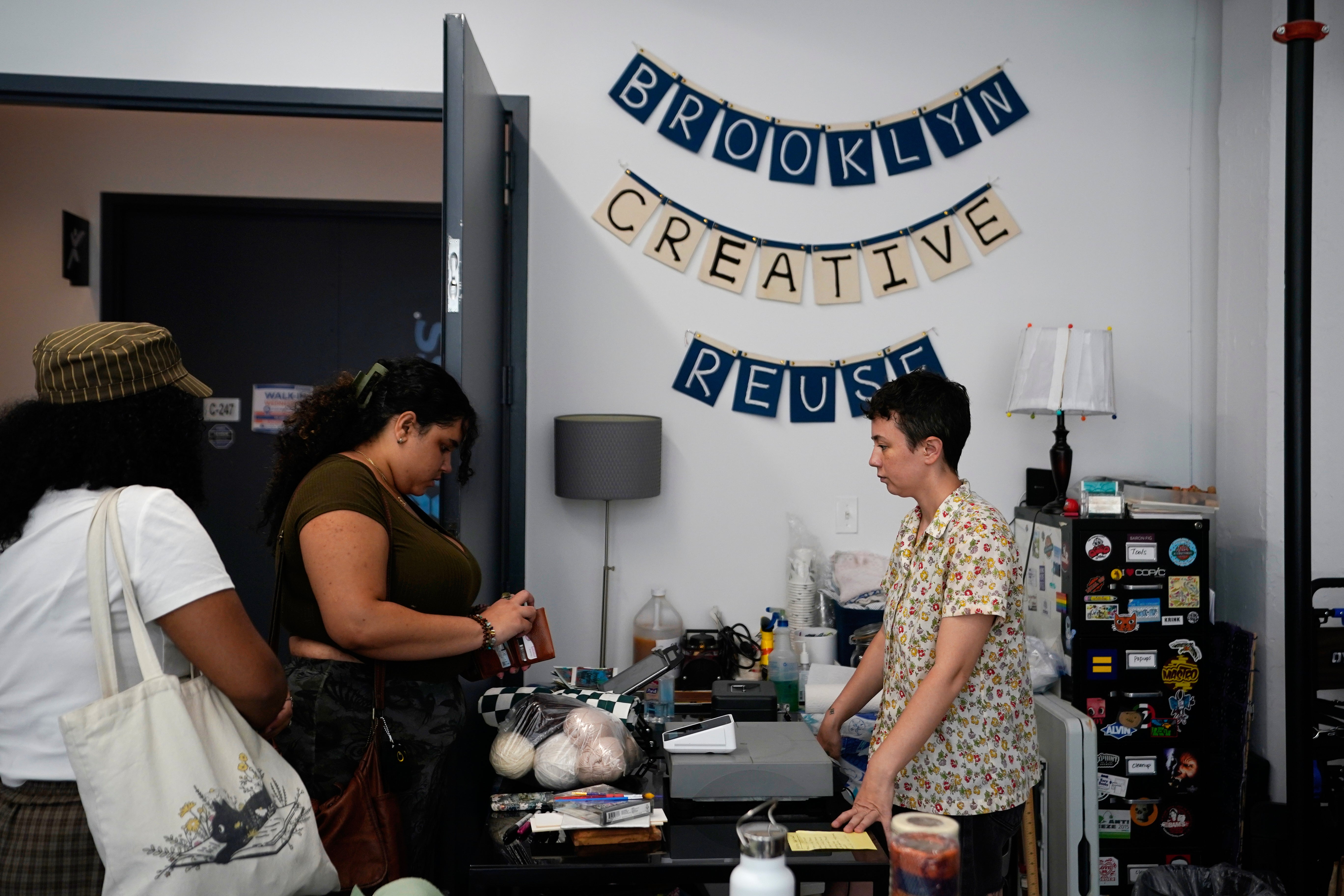 Stephanie O'Brien, right, helps shoppers pay for art supplies at the Brooklyn Creative Reuse (AP Photo/Alyssa Goodman)