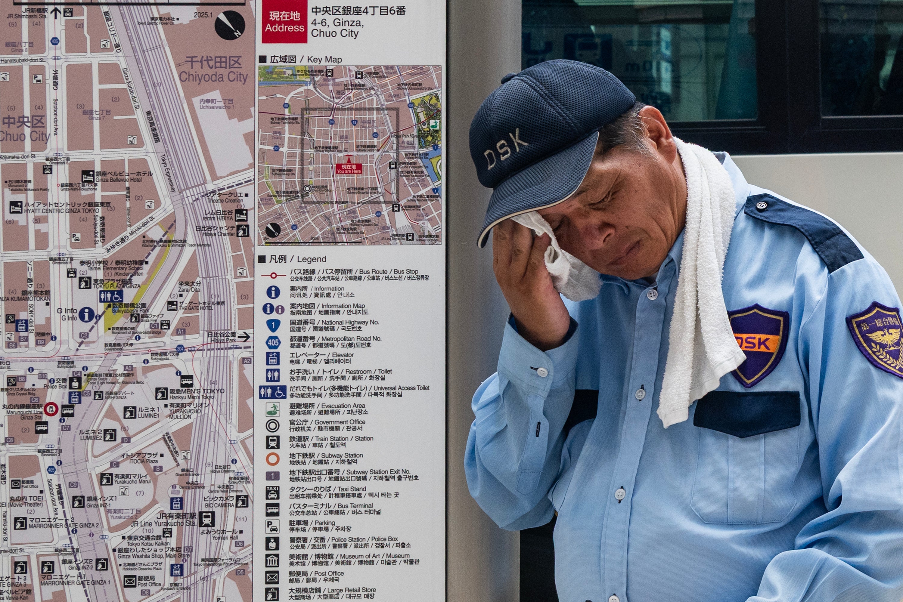 A security guard wipes his face on a hot day in Tokyo