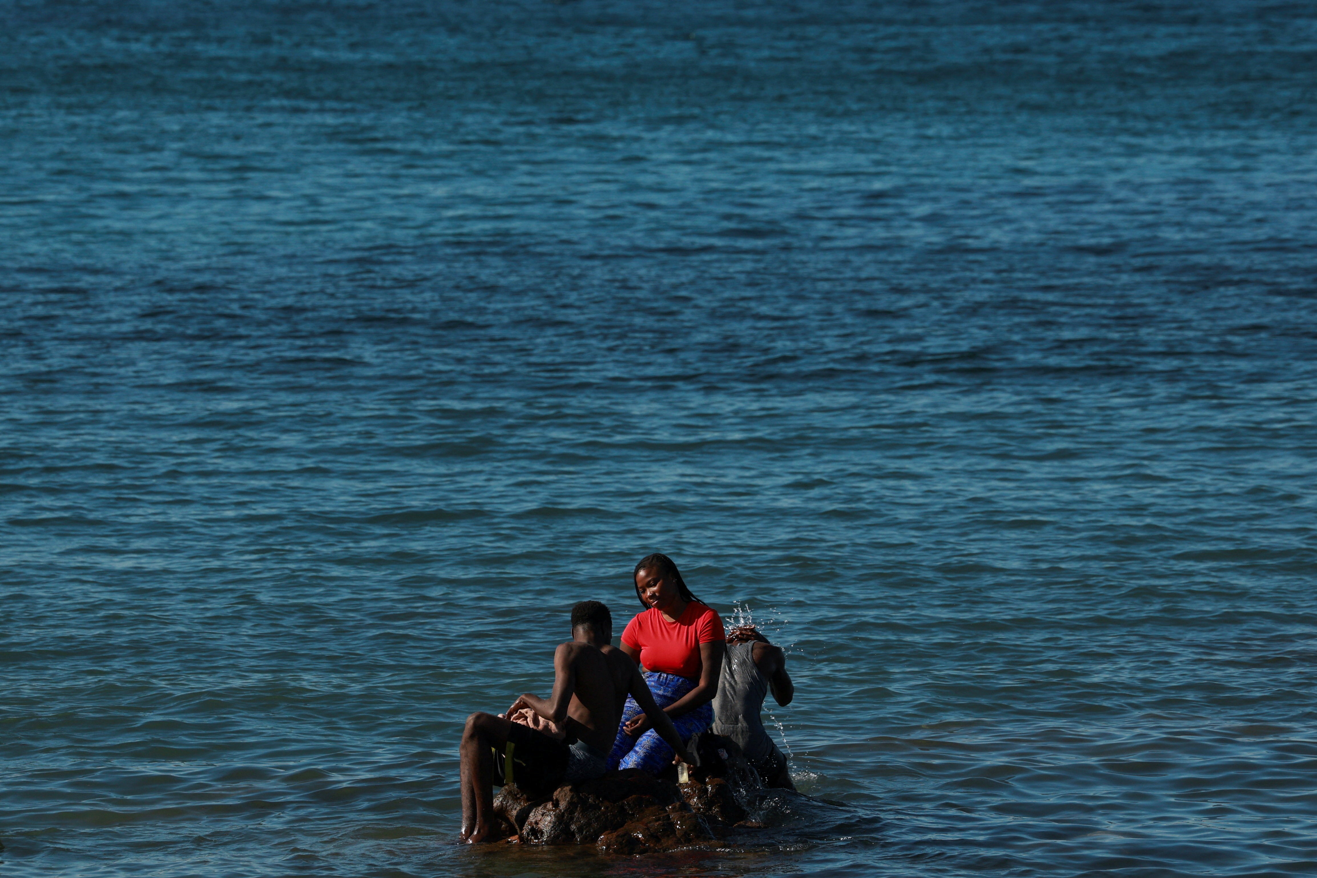 Migrants wait at a beach in Ceuta, Spain, following deadly mass crossings of migrants on foot and by sea from Morocco into Spanish territory, August 3, 2026 (Reuters)