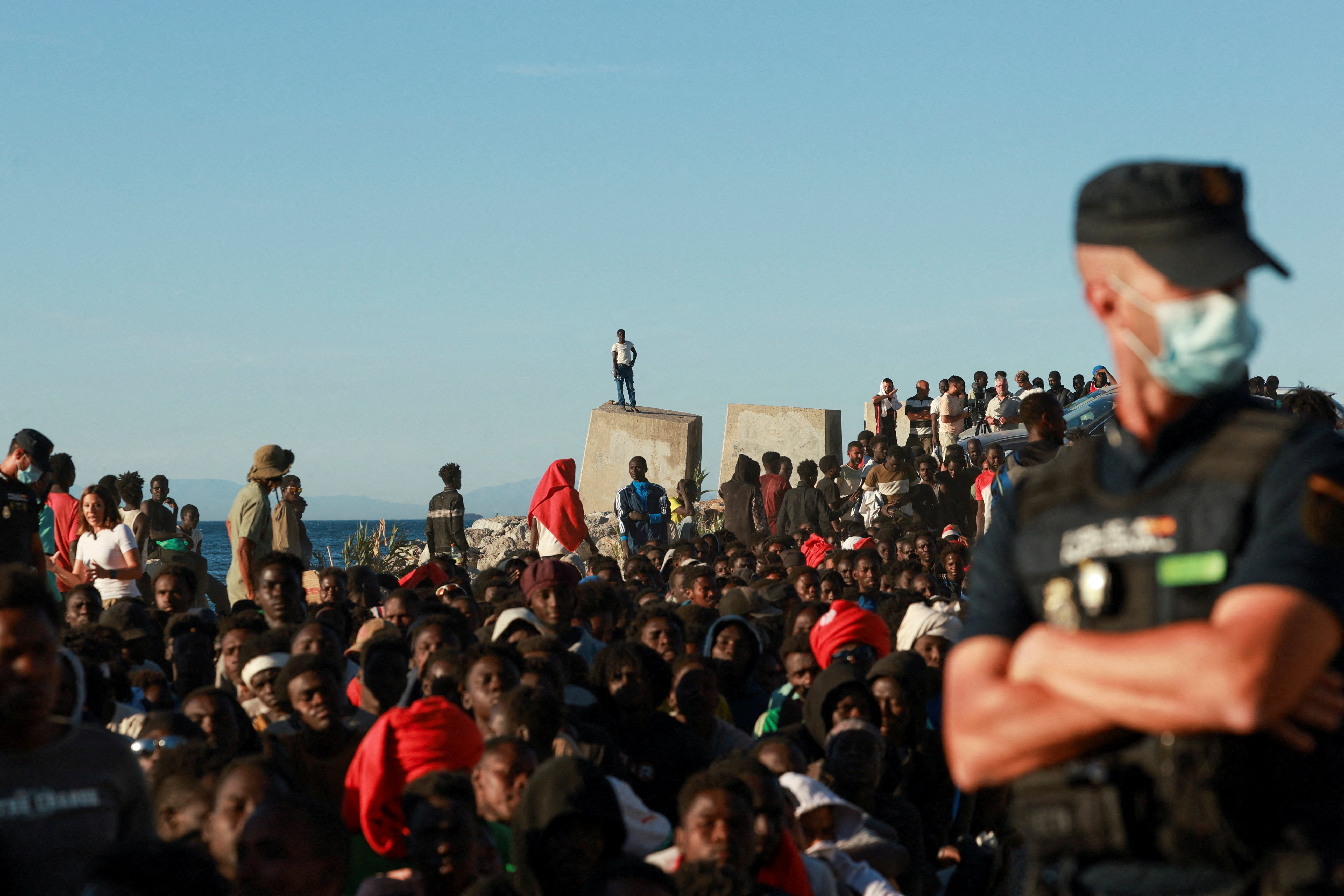 Migrants wait in line to receive food and beverage from the Red Cross, following mass crossings of migrants on foot and by sea from Morocco into Spanish territory, in Ceuta, Spain, August 3, 2026 (Reuters)