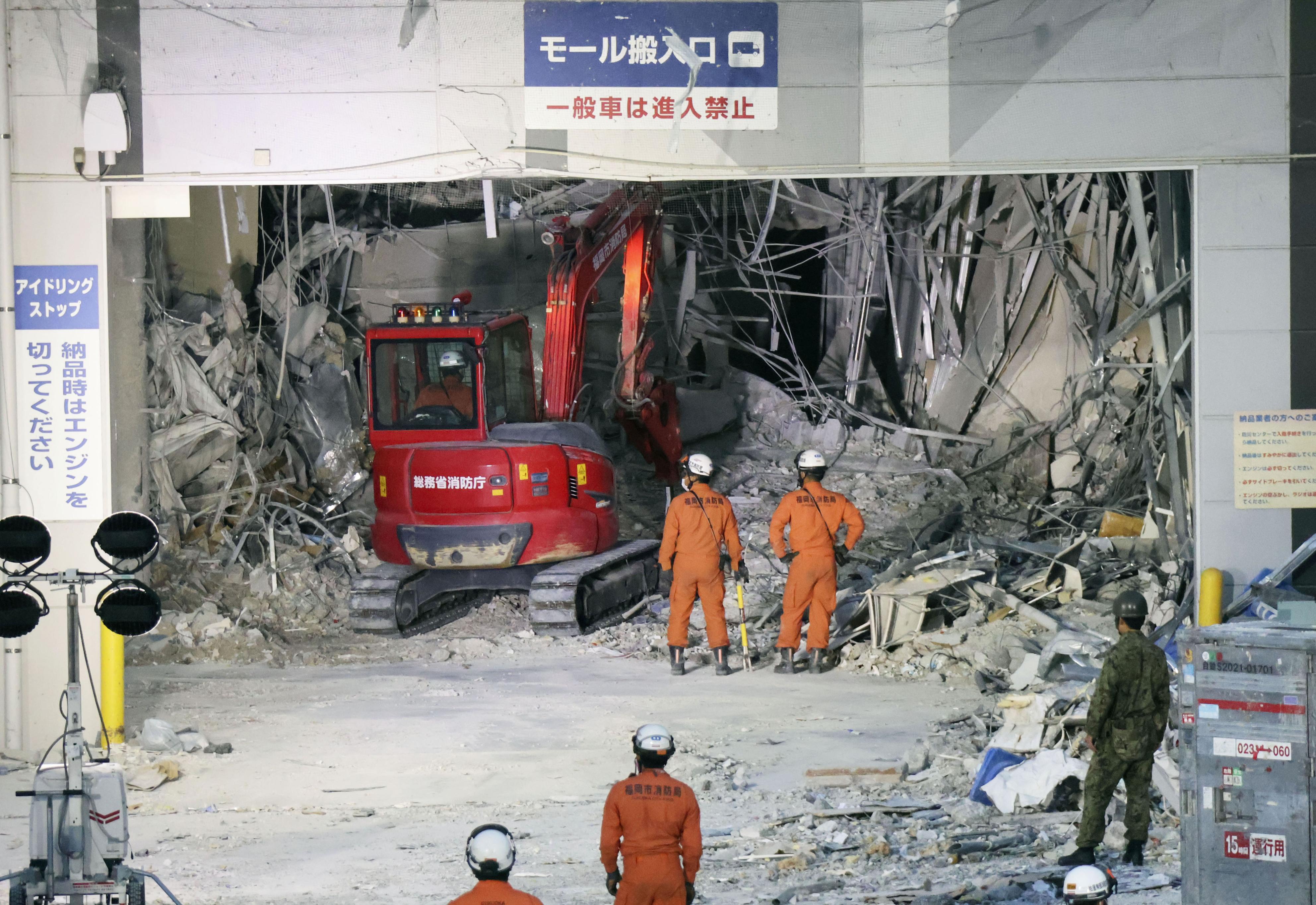 Heavy machinery removes debris at AEON Mall, which was damaged by an explosion following an earthquake, in Kashima, Kumamoto Prefecture