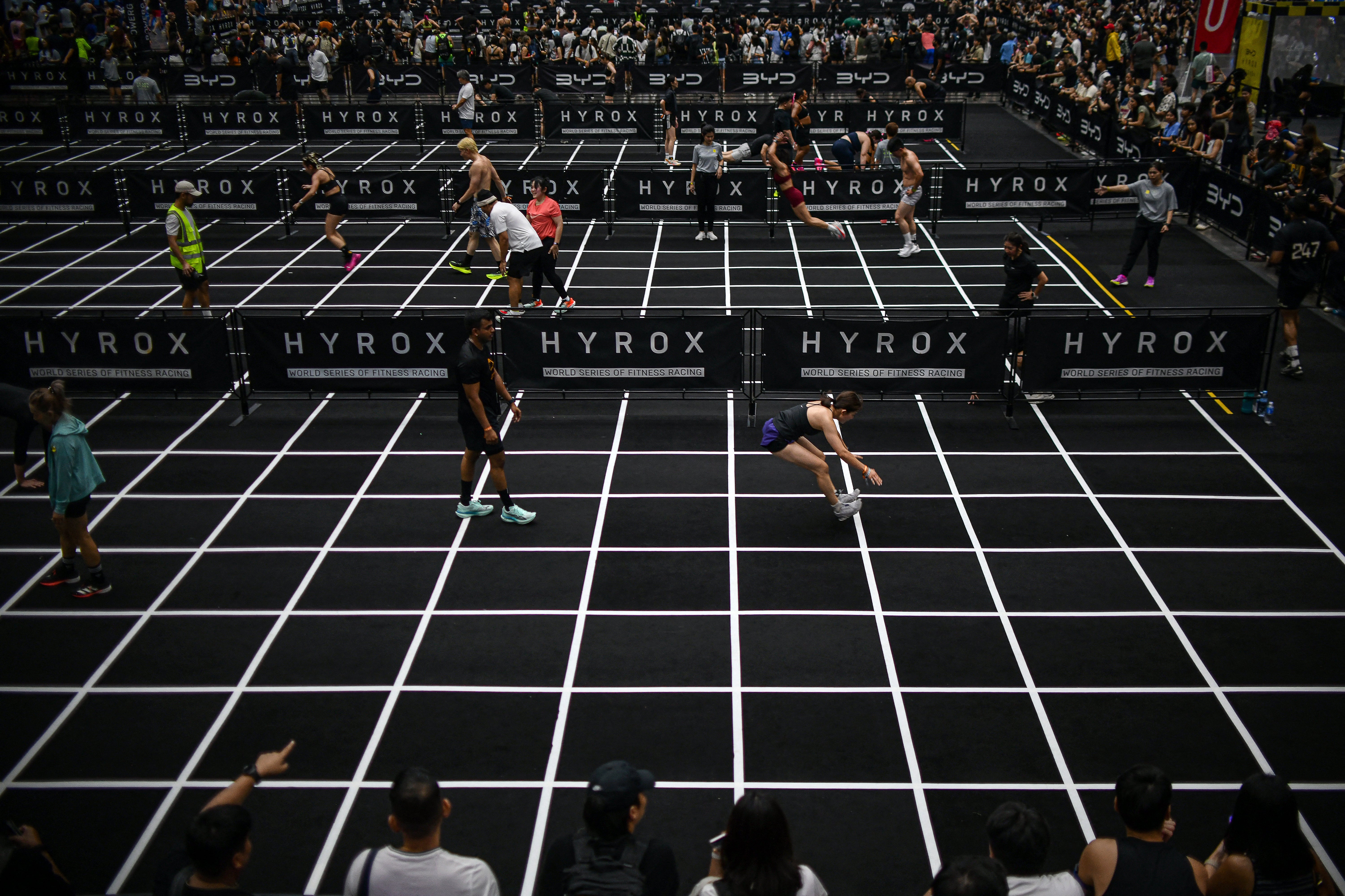 Participants compete in the "burpee broad jumps" event during the Hyrox fitness race in Bangkok on March 21, 2026