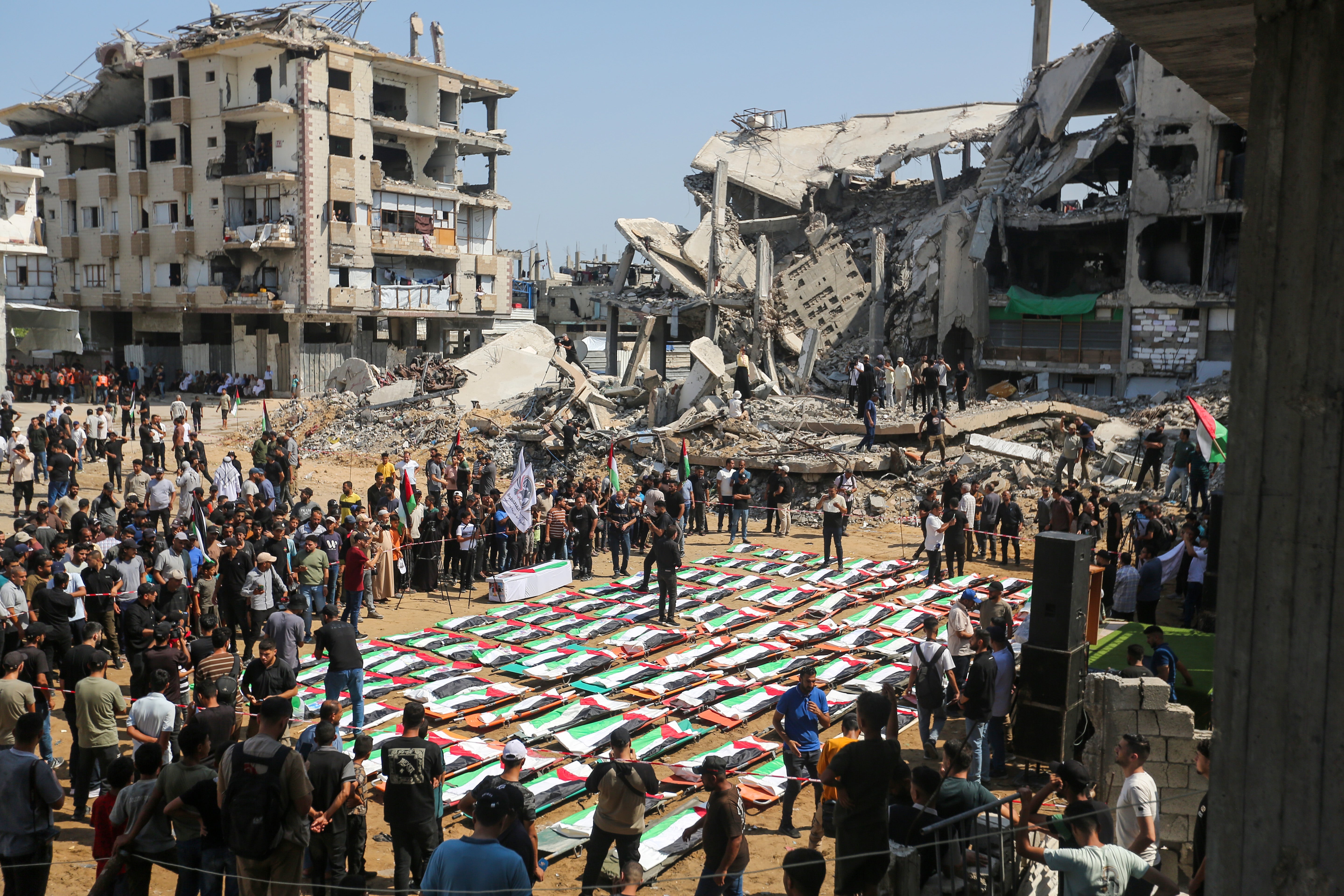 People attend a mass funeral for members of the Abu Sharia and Al-Hasayna families, whose remains were recently recovered from the rubble of their homes after an attack earlier in the war, on August 4 (Getty)