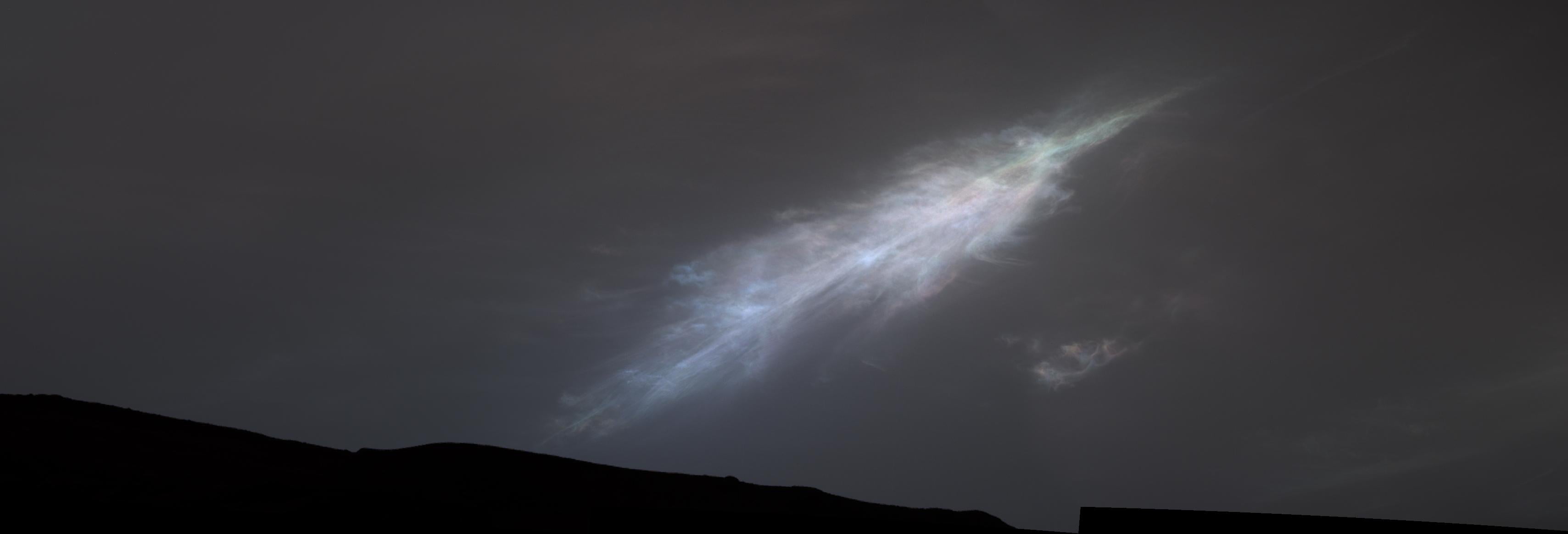A feather-shaped iridescent cloud was captured by NASA’s Curiosity Mars rover just after sunset in January 2023. NASA says the clouds form from dry ice on the Red Planet