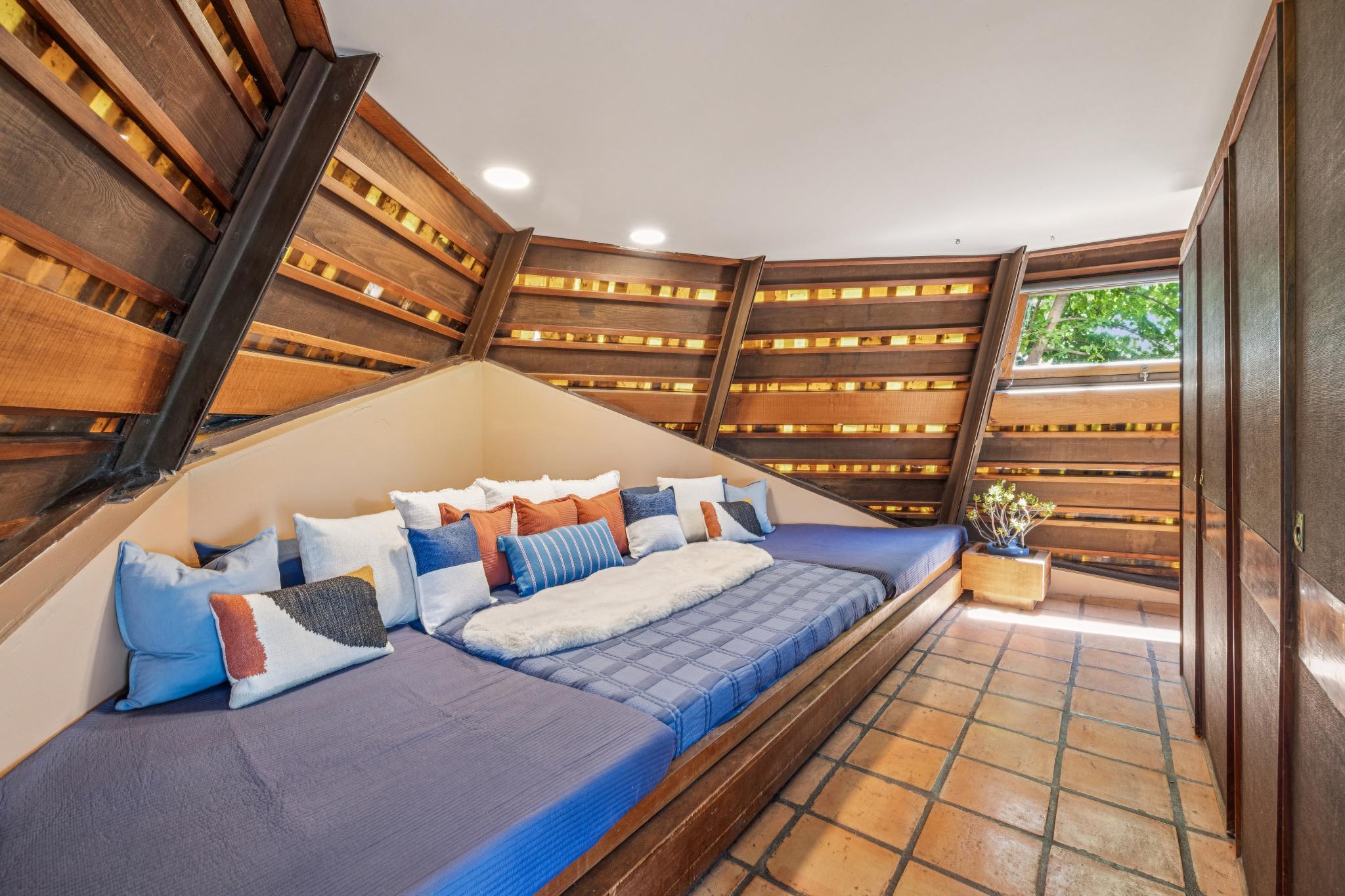 A nook with a built-in bed on the ground level serves as the primary bedroom (Open Homes Photography)