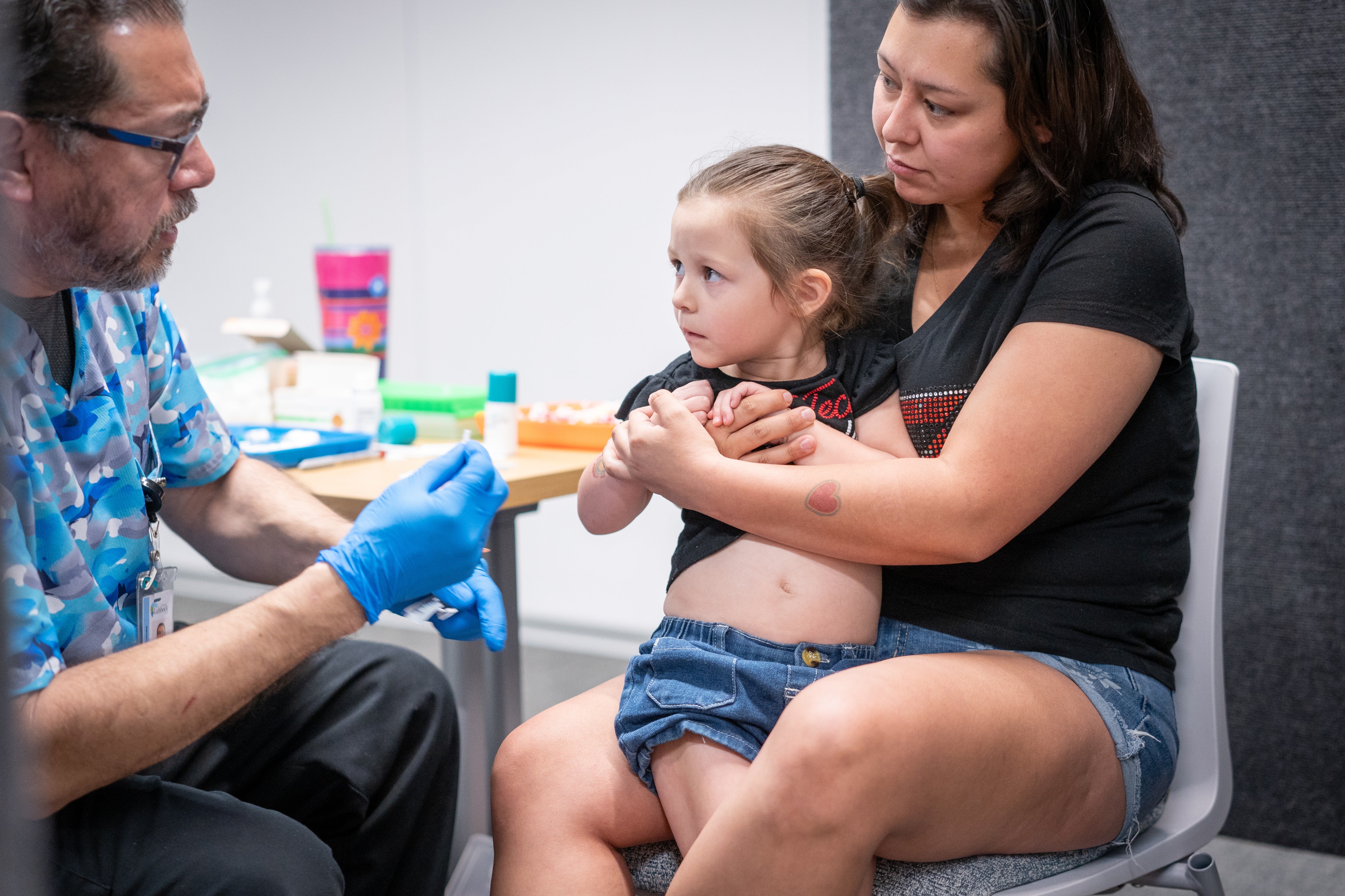 A woman holds her young daughter while she gets the MMR vaccine at a clinic in Lubbock, Texas, last year. Kennedy said parents should give their children the shots on CNN this weekend (Getty Images)