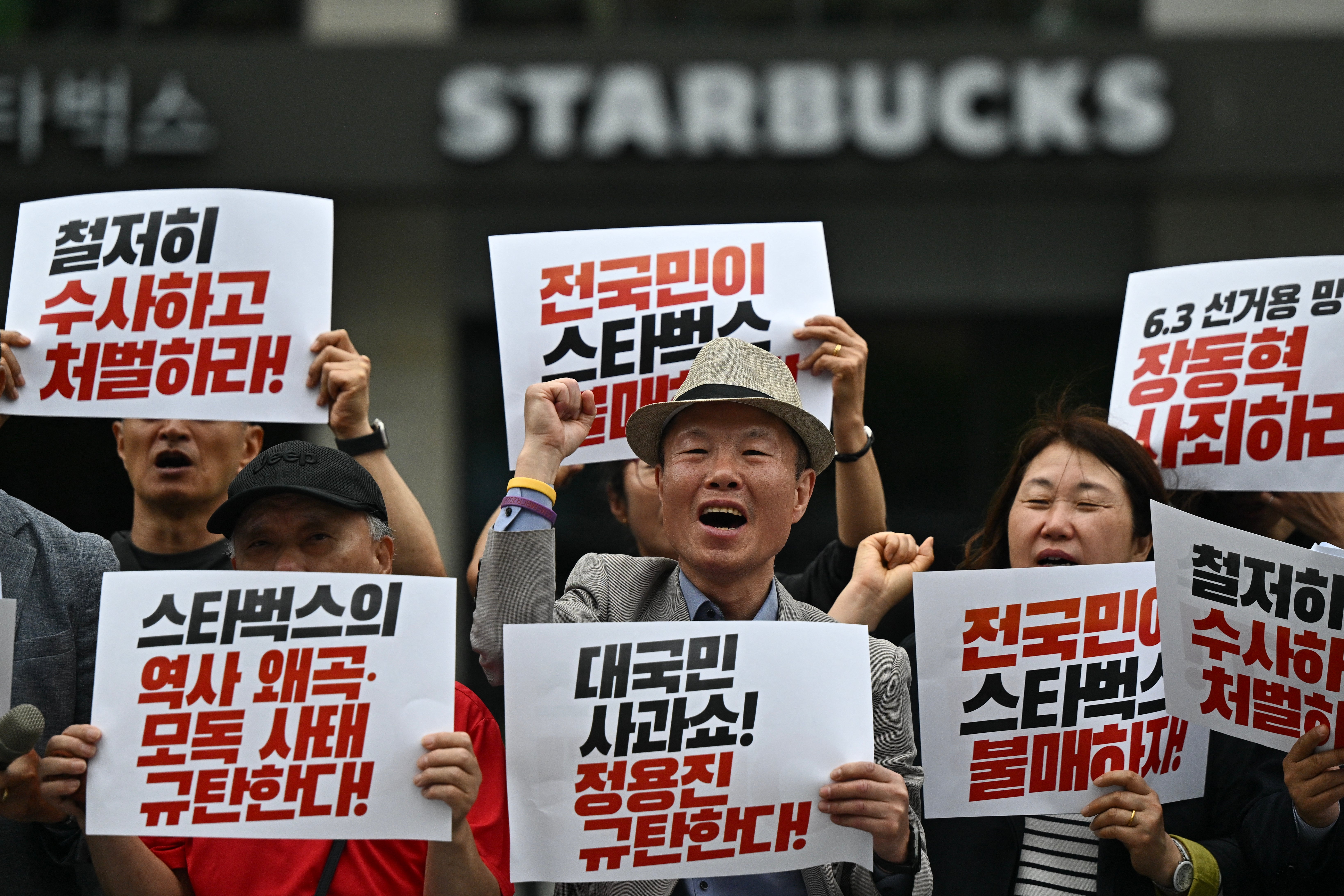 Activists hold placards as they take part in a rally calling for a boycott of the Starbucks coffee chain in Seoul (AFP/Getty)