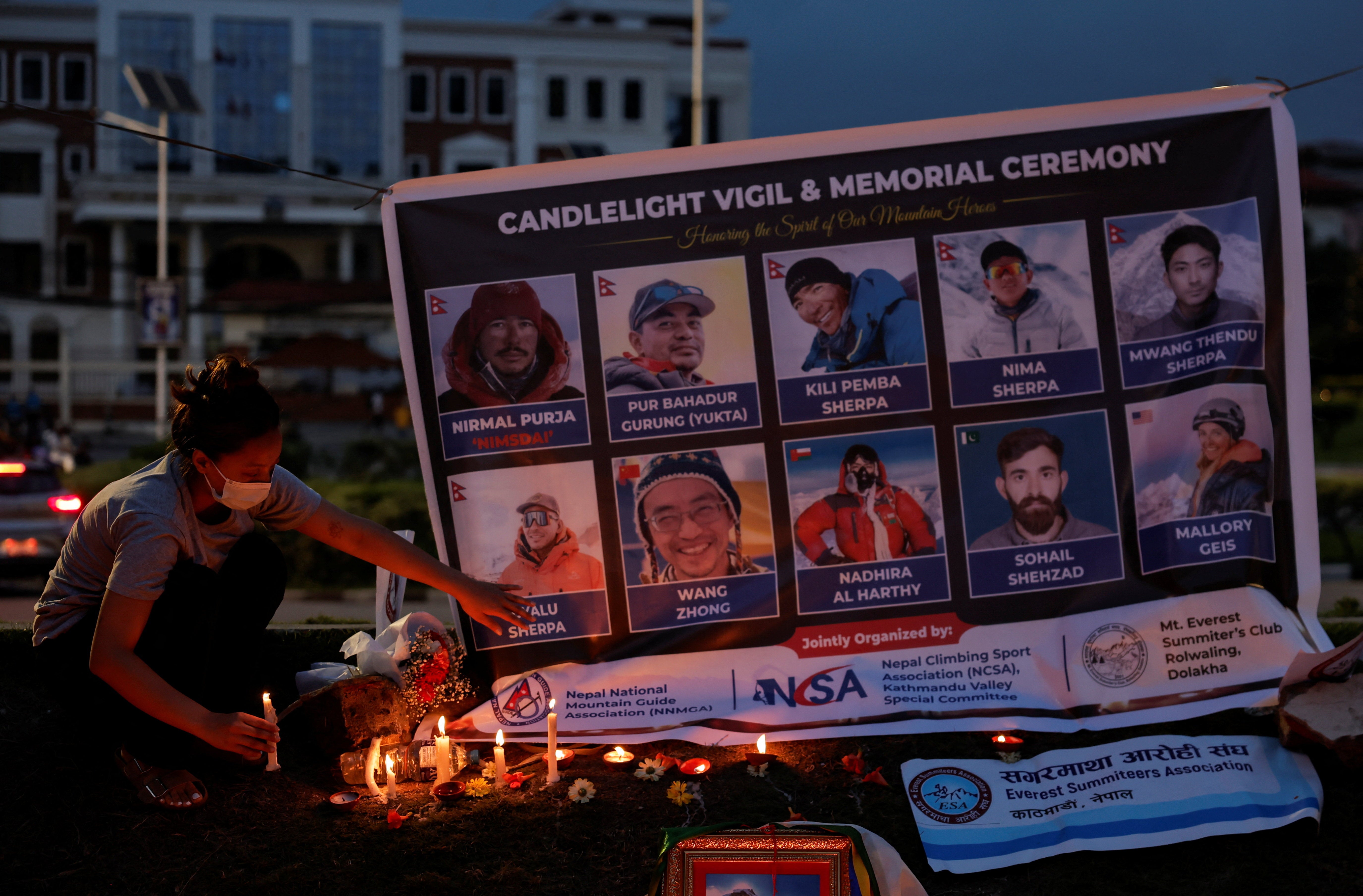 Dawa Chhinzum Sherpa, daughter of Kili Pemba Sherpa, who died in an avalanche while summiting Broad Peak in Pakistan, offers a candle during a vigil to honour climbers, including celebrated British-Nepali climber Nirmal Purja, also known as Nimsdai, in Kathmandu, Nepal, 4 August 2026